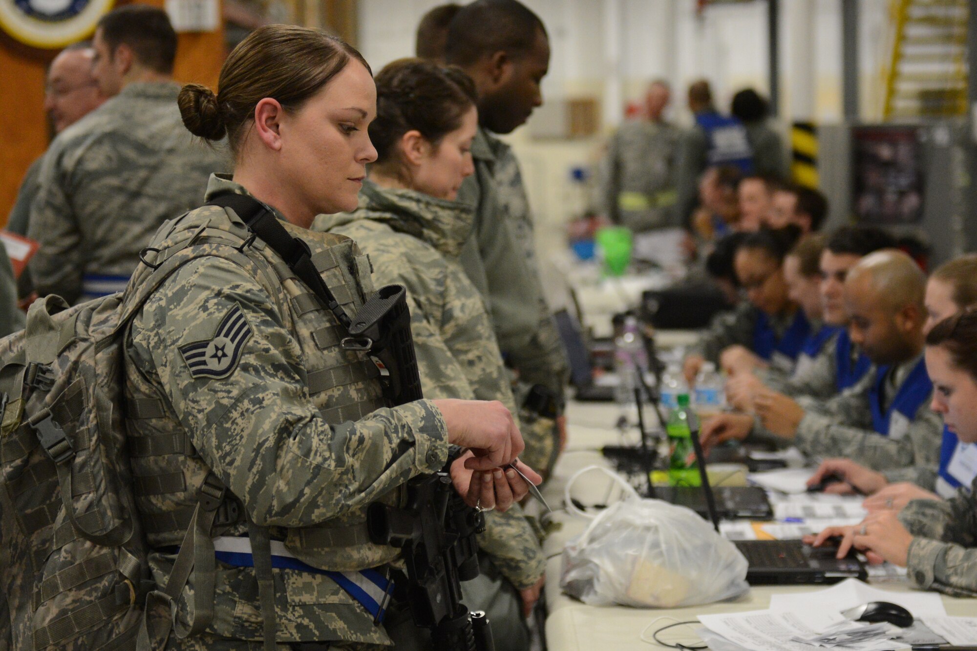 Staff Sgt. Cristina Garcia gets her records inspected as she waiting in the mobility processing line Jan. 10, 2014 at Scott Air Force Base, Ill. The three-day exercise evaluated the 375th Air Mobility Wing's ability to process personnel and cargo for contingencies. Wood is a reenlistment specialist for the 375th Force Support Squadron. (U.S. Air Force photo/Senior Airman Jake Eckhardt)