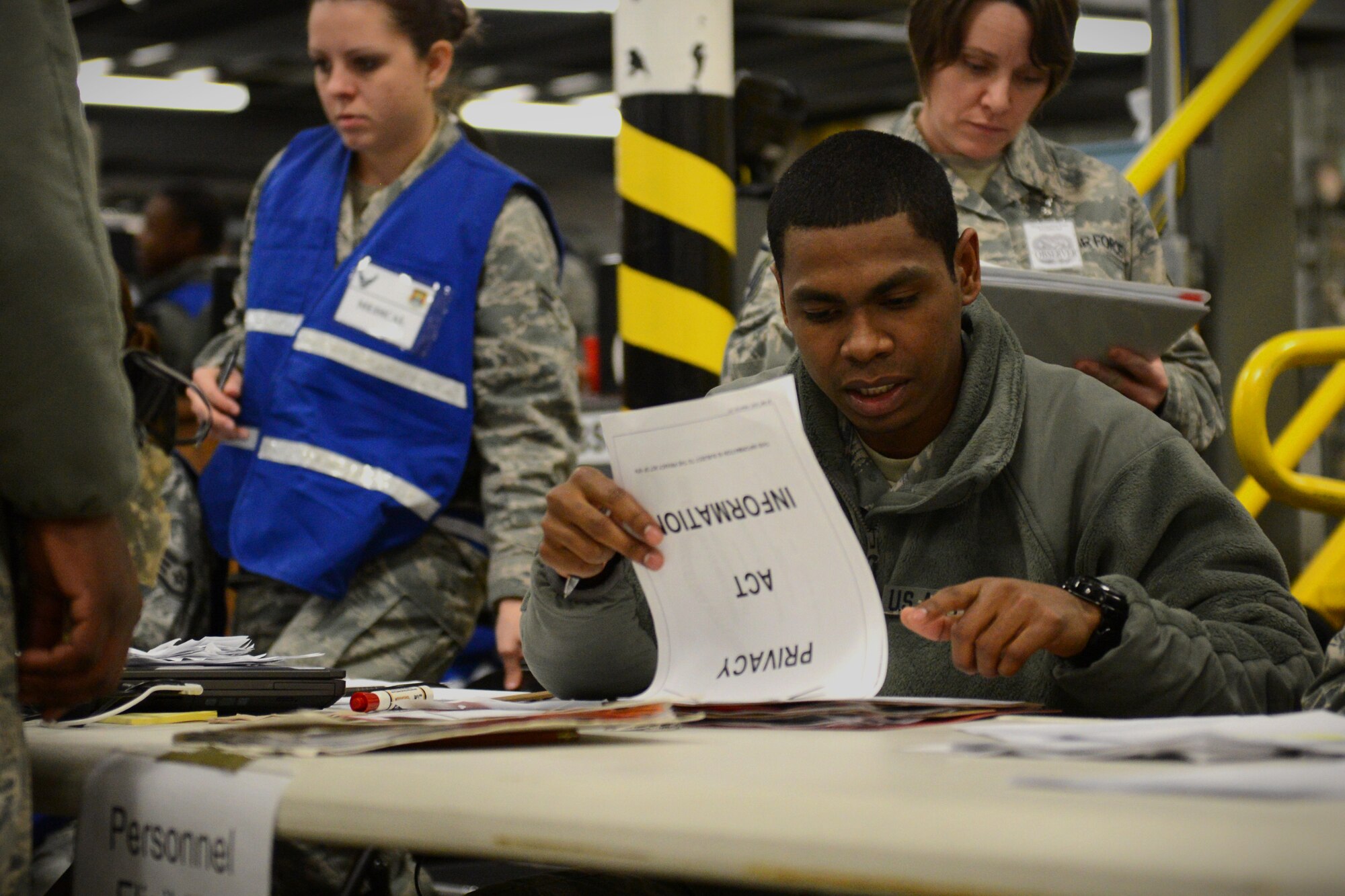 Airman 1st Class Collin Wood looks through the records of an exercise deployer who is going through a mobility processing line Jan. 10, 2014 at Scott Air Force Base, Ill. The three-day exercise evaluated the 375th Air Mobility Wing's ability to process personnel and cargo for contingencies. (U.S. Air Force photo/Senior Airman Jake Eckhardt)