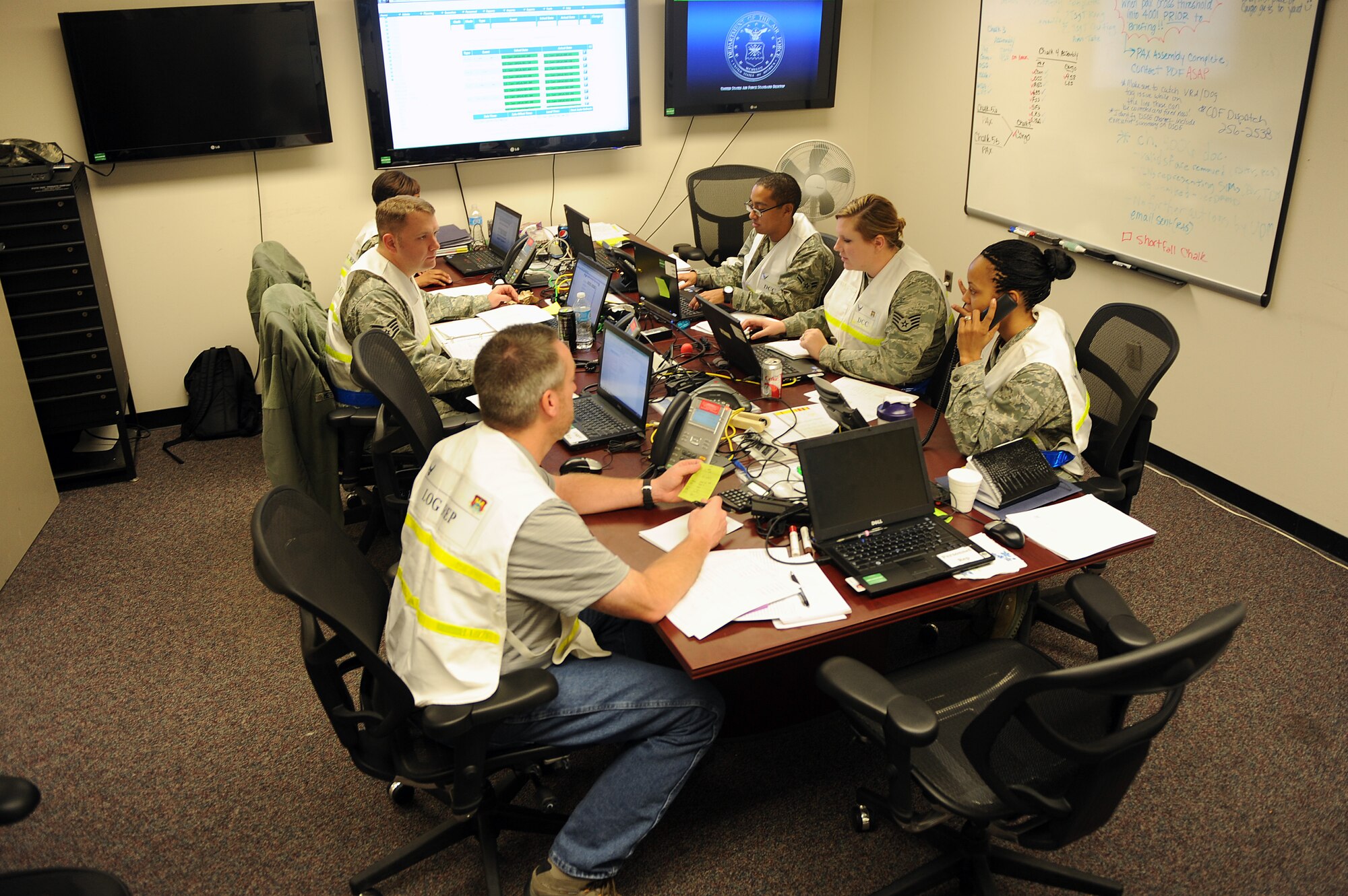 Members of the Deployment Control Center relay information to base personnel during a mobility exercise Jan. 11, 2014, Scott Air Force Base, Ill.  The exercise provided an opportunity for the 375th Air Mobility Wing to test capabilities and procedures while ensuring Airmen maintain readiness to support Department of Defense Operations. (U.S. Air Force photo/Senior Airman Divine Cox)