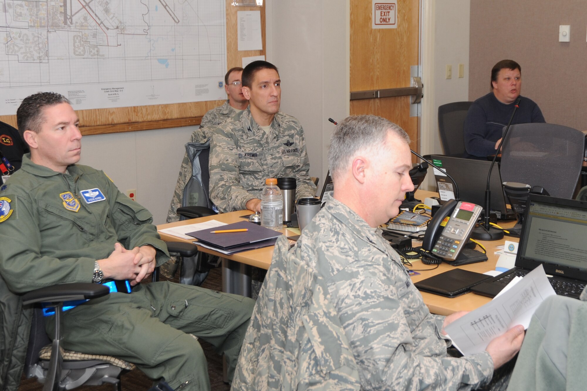 Col. Kyle Kremer and other commanding officers receive a briefing at the Crisis Action Team center during an exercise Jan. 10, 2014, Scott Air Force Base, Ill. The exercise evaluated the 375th Air Mobility Wing's ability to process personnel and cargo for contingencies. Kremer is the 375th Air Mobility Wing commander. (U.S. Air Force photo/Airman 1st Class Megan Friedl)