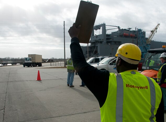 Tyrone Aken, Honeywell material coordinator, directs a truck into the shipyard after it rolls off the USNS Pomeroy (T-AKR-316), Jan. 7, 2014 at Joint Base Charleston – Weapons Station, S.C. Once equipment is in the shipyard, the material coordination team scan the items before it is turned over to the Army Strategic Logistics Activity Charleston for maintenance. Once re- loaded onto a ship, the equipment is prepositioned overseas for 18 to 36 months near potential hotspots until it is needed by the warfighter. (U.S. Air Force photo/Staff Sgt. William O’Brien)

