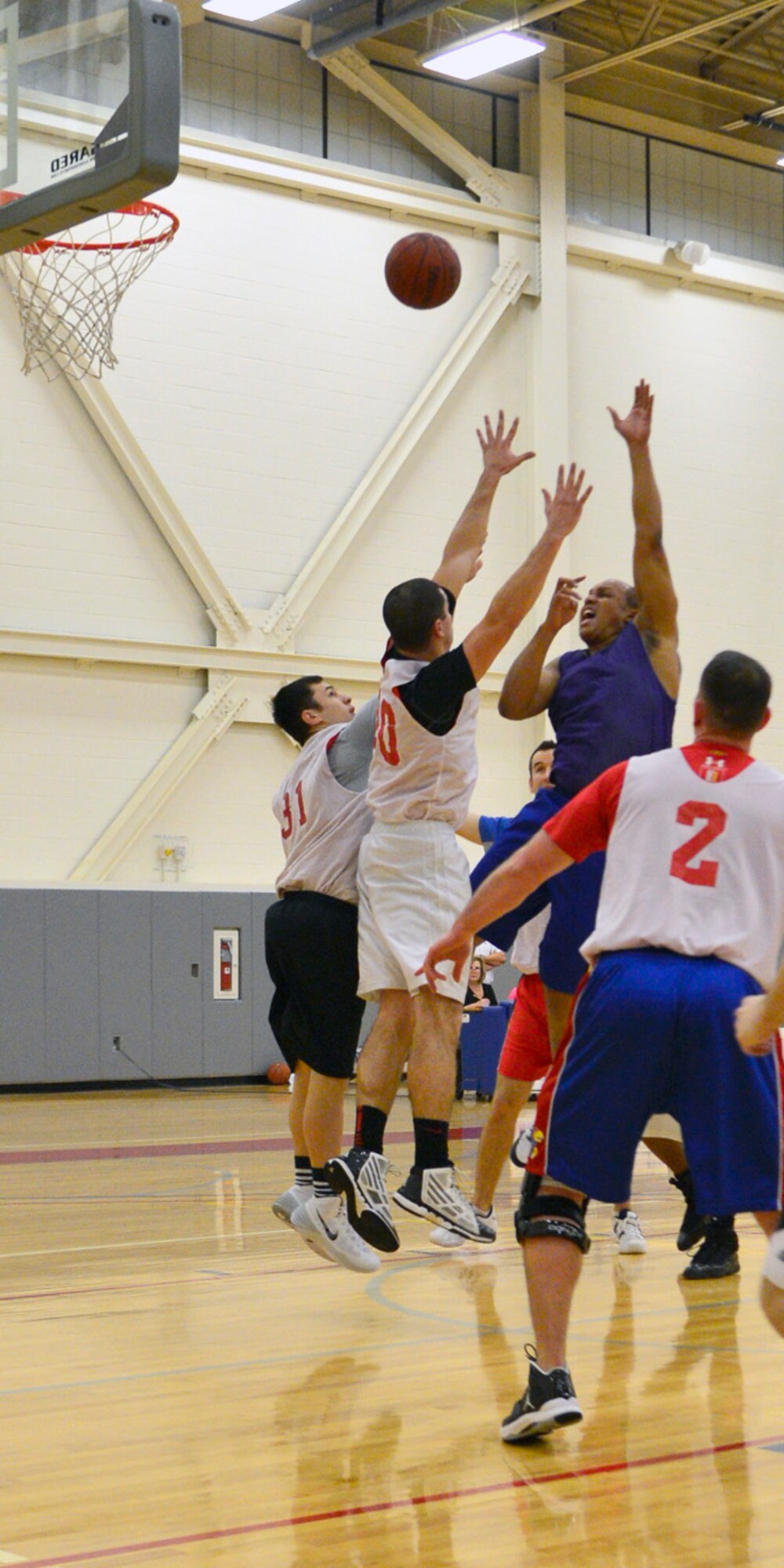 Ray Pitt, 436th Medical Group forward, shoots a turn-around jumper as several members of the 9th Airlift Squadron intramural basketball team attempt to block the shot Jan. 13, 2014, at the fitness center on Dover Air Force Base, Del. Pitt scored eight points as the 436th MDG cruised to a 52-27 victory. (U.S. Air Force photo/Airman 1st Class William Johnson)