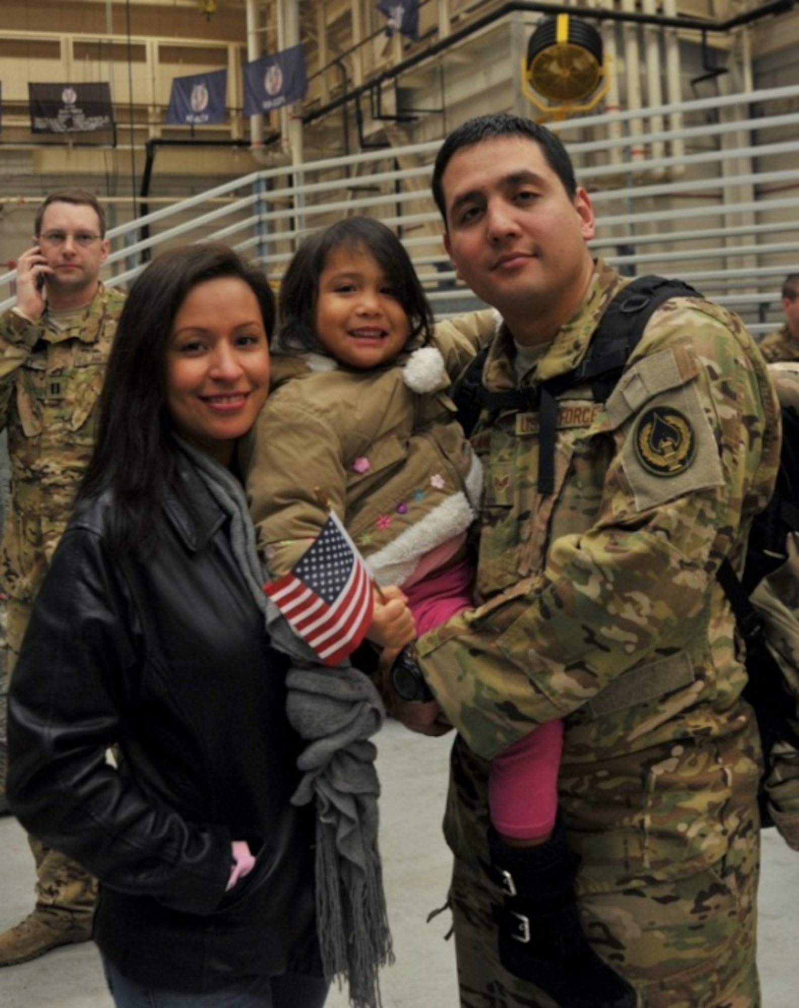 Staff Sgt. Eduardo Arellano, 15th Special Operations Squadron flight engineer, stands with his wife, Cynthia Arellano, and daughter, Gabriella Arellano, at Hurlburt Field, Fla., Jan. 10, 2014. Families gathered at 3:15 a.m. to greet the Airmen who returned home. (U.S. Air Force photo/Airman 1st Class Andrea Posey)