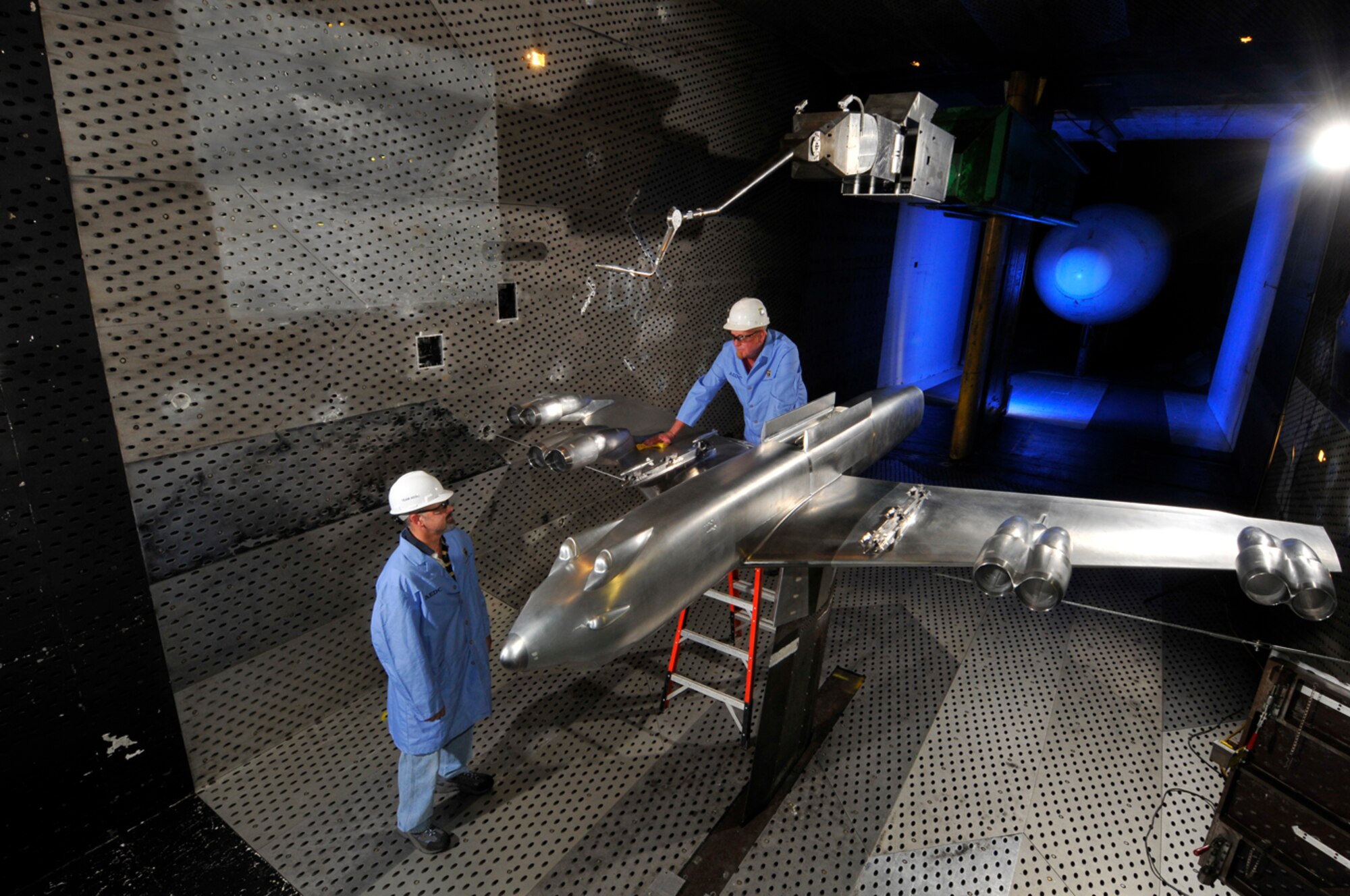 AEDC set a record with the largest aircraft model (10 percent scale model) by conducting B-52 Stratofortress store separation tests. The testing was requested from the B-52 Program Office to look at the scope of the internal weapons bay upgrade to include additional multitude of weapons that previously had not been released from the B-52 weapons bay. Due to results and data generated from tests, modifications are currently underway to increase the B-52’s guided-weapon capacity. The increased capacity will enable the Joint Direct Attack Munition (JDAM), Joint Air-to-Surface Standoff Missile (JASSM), Miniature Air Launched Decoy (MALD) and the MALD Jammer to be carried internally.  From left, J.T. Thompson, Aerospace Testing Alliance (ATA) captive trajectory system project engineer, discusses the B-52H model with Gary Cunningham, ATA lead outside machinist, in the AEDC Propulsion Wind Tunnel 16-foot wind tunnel between store separation test runs. (Photo by Rick Goodfriend)