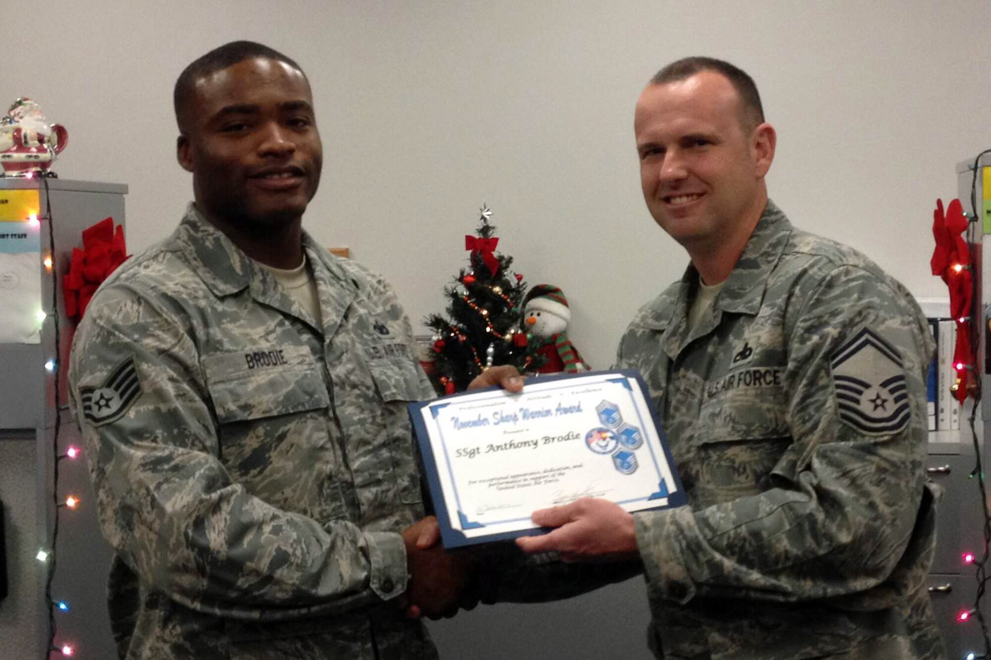 PETERSON AIR FORCE BASE, Colo. – Senior Master Sgt. Brian Smith (right), on behalf of the Pikes Peak Top 3, presents the November 2013 Sharp Warrior Award to Staff Sgt. Anthony Brodie from the 21st Security Forces Squadron. Brodie displayed impeccable character and military bearing while completing his duties as both the base confinement NCO as well as the security forces augmentee program manager. As the confinement NCO Brodie interacts with a multitude of different military and civilian agencies, usually under less than ideal circumstances, and does so while presenting a professional military image. Brodie not only displays outstanding military bearing but goes out of his way to ensure he provides the highest level of customer server possible. (U.S. Air Force photo)