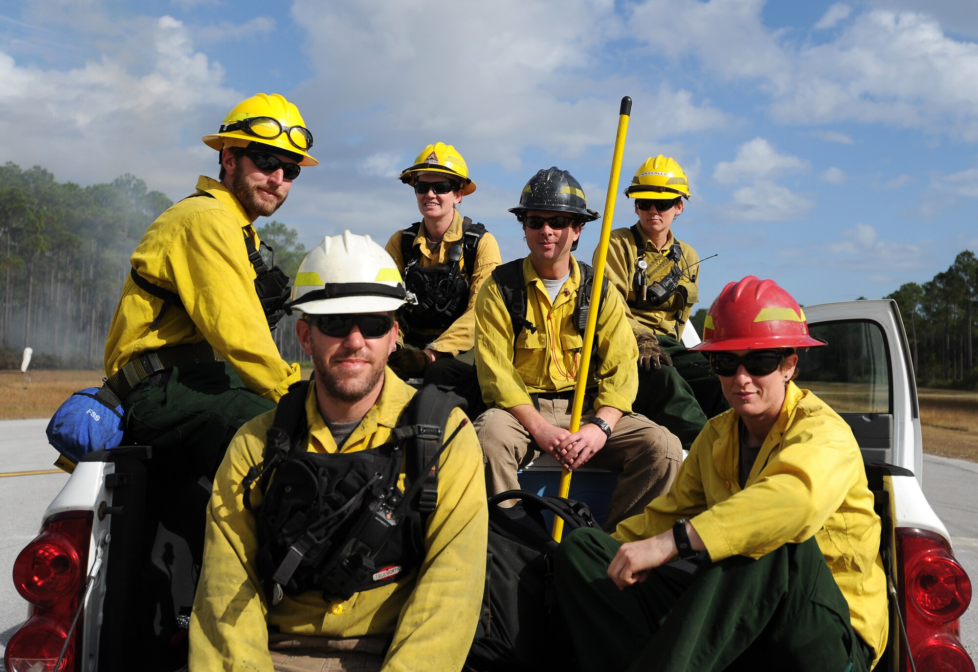 U.S. Forest Service fire detailers, ride on the back of a truck during a prescribed burn Nov. 21 at the Silver Flag Exercise Site, Tyndall Air Force Base, Fla. The burns clear undergrowth and allow for healthier forests while lowering the possibility of wildfires. (U.S. Air Force photo by Airman 1st Class Alex Echols)
