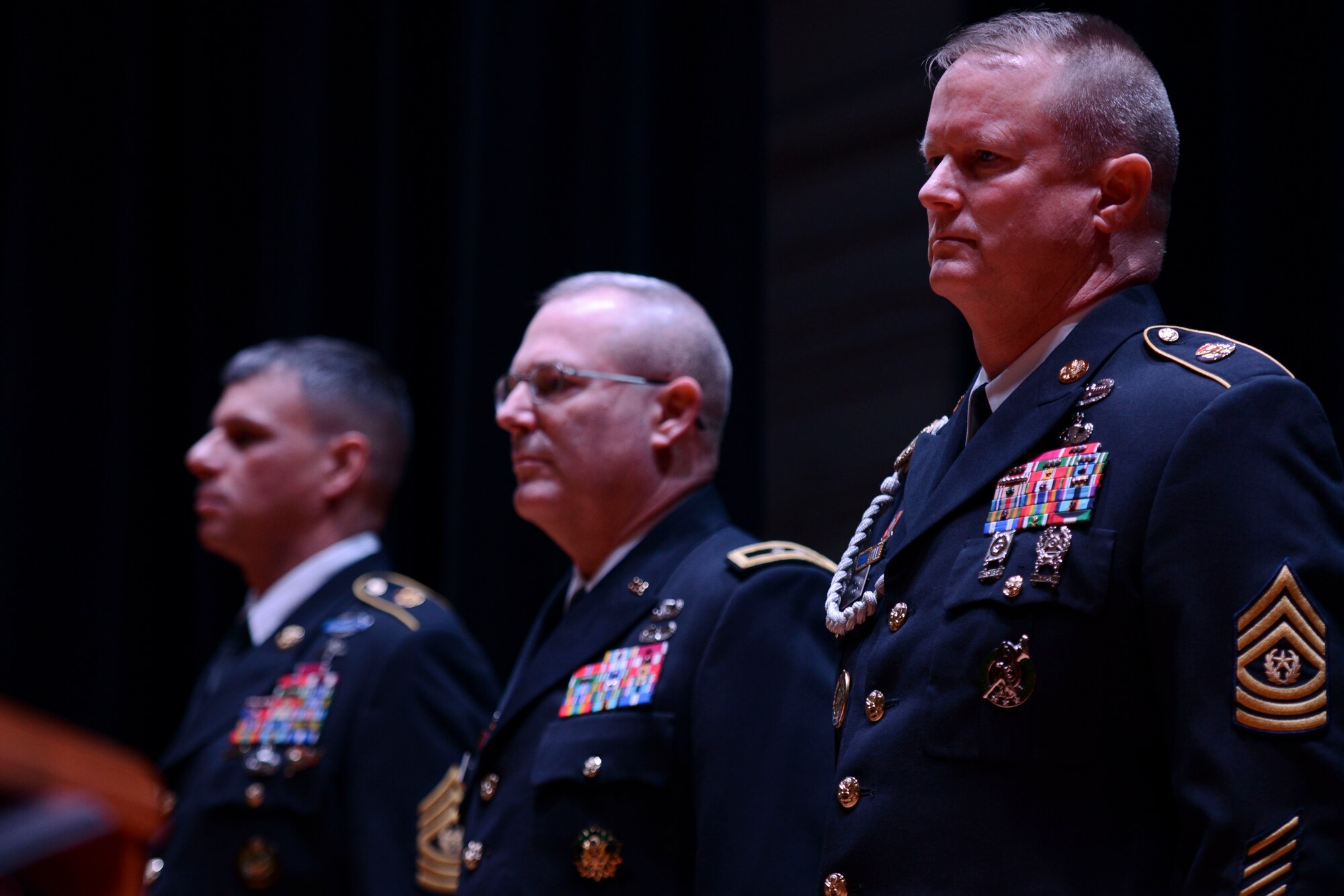 From left, U.S. Army Sgt. Maj. John Calpena, U.S. Army Training and Doctrine Command Initial Military Training command sergeant major, U.S. Army Maj. Gen. Ross Ridge, IMT deputy commanding general and Sgt. Maj. Dennis Woods, incoming IMT command sergeant major, stand at attention during a change of responsibility ceremony inside Wylie Theater at Fort Eustis, Va., Jan. 10, 2014. Woods most recently served as the command sergeant major for the 191st Infantry Brigade, First Army Division West.  (U.S. Air Force photo by Staff Sgt. Ciara Wymbs/Released)