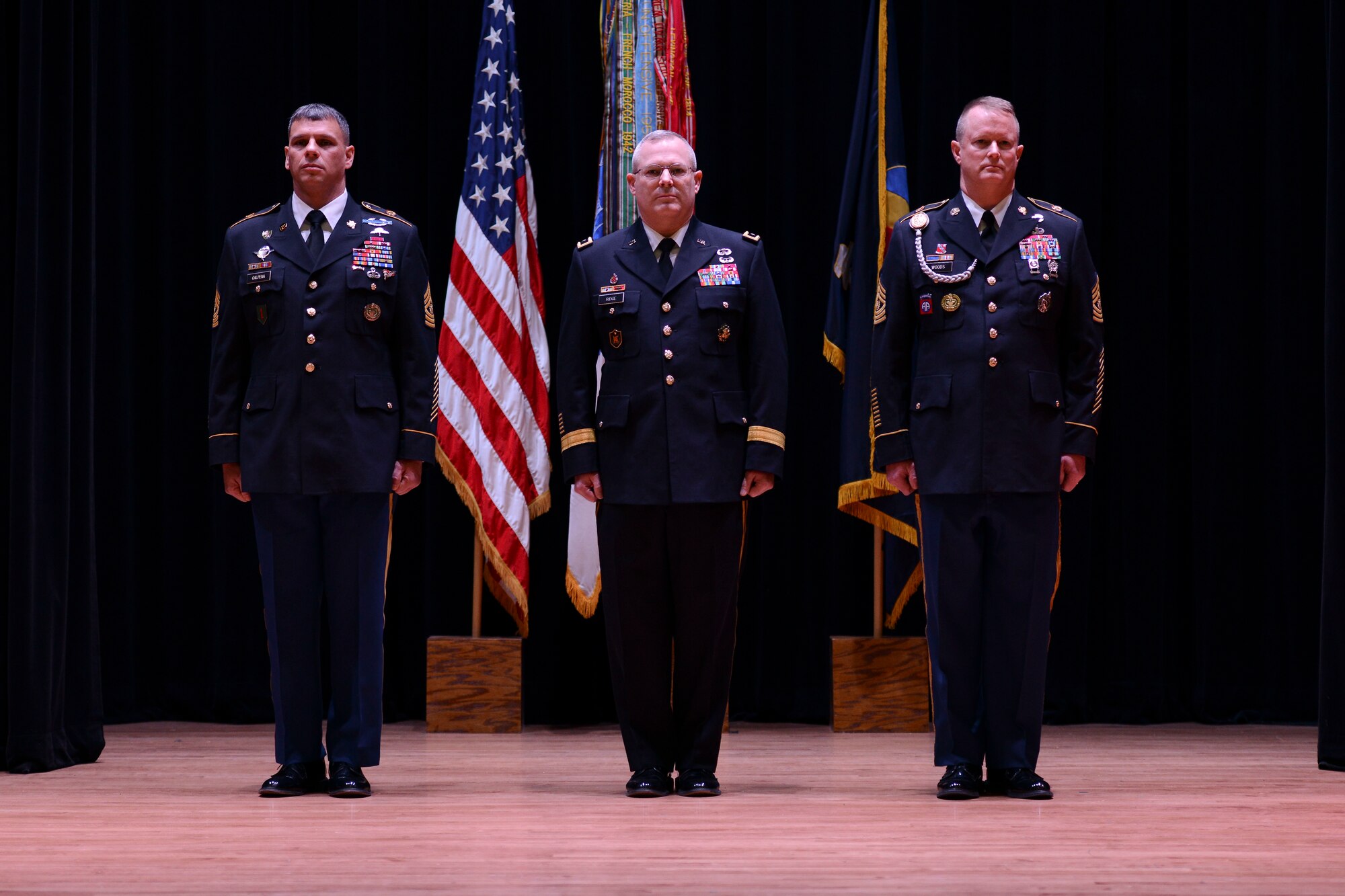 From left, U.S. Army Sgt. Maj. John Calpena, U.S. Army Training and Doctrine Command Initial Military Training command sergeant major, U.S. Army Maj. Gen. Ross Ridge, IMT deputy commanding general and Sgt. Maj. Dennis Woods, incoming IMT command sergeant major, stand at attention during a change of responsibility ceremony inside Wylie Theater at Fort Eustis, Va., Jan. 10, 2014. Calpena has served as the command sergeant major since May 2010. (U.S. Air Force photo by Staff Sgt. Ciara Wymbs/Released)