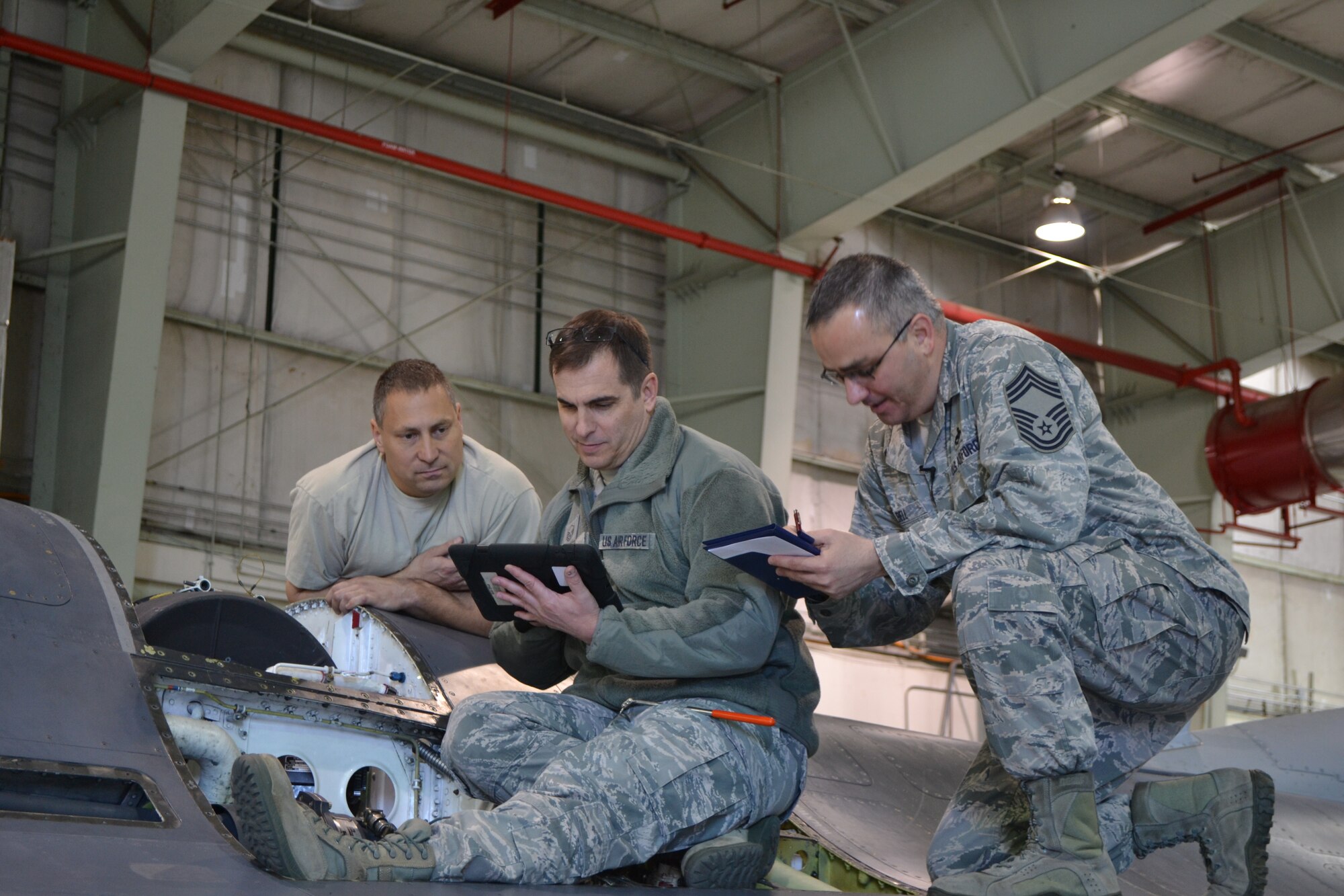 Tech. Sgt. Alan Columbo, 301st aircraft weapons systems technician (left), stands by his craftsmanship atop an F-16 while Master Sgt. Owen Cook (center), and Chief Master Sgt. Steve Bell, apply their Quality Assurance expertise during an inspection of the aircraft's 20mm cannon. (U.S. Air Force photo/TSgt Shawn McCowan)