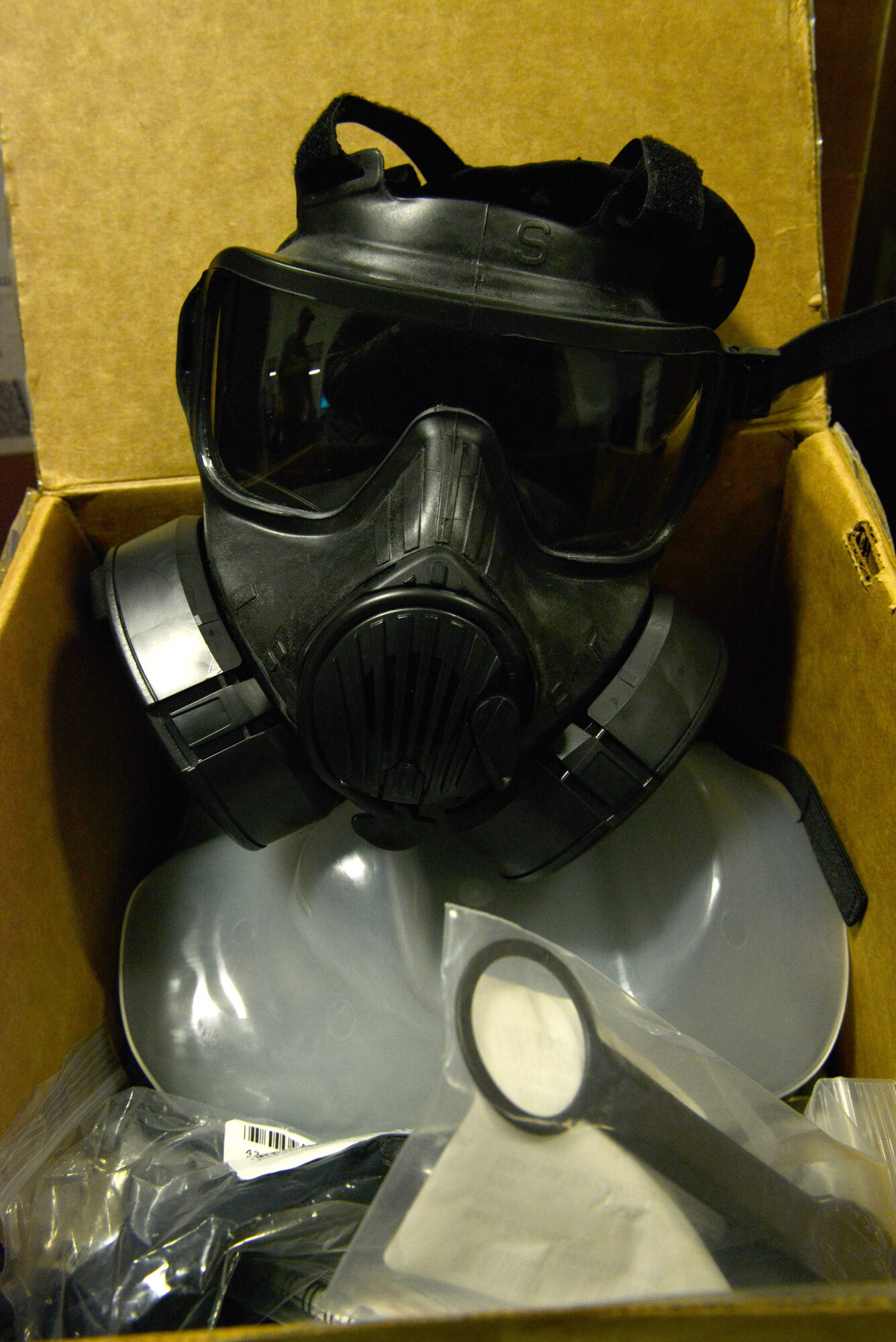 A gas mask sits in a box along with eight other components at the Chandler Deployment Processing Center Shaw Air Force Base, S.C., Jan. 9, 2014. The 20th Logistics Readiness Squadron had prepared to issue approximately 815 Airmen their gas mask over the course of four days for an operational readiness exercise. (U.S. Air Force photo by Airman 1st Class Jensen Stidham/Released)