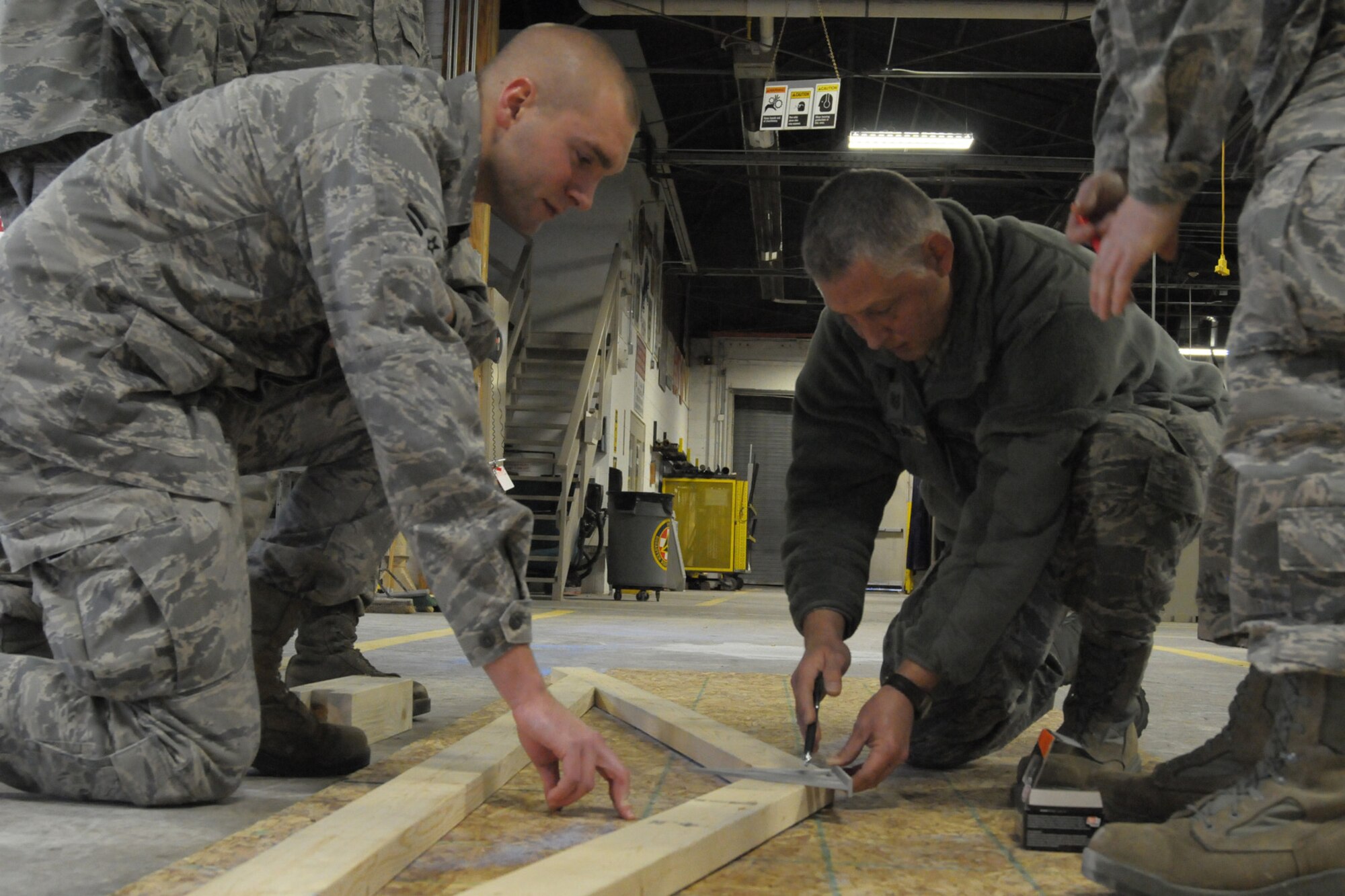 14-0112-Z-YW189-017- Technical Sergeant Dan Gerlach, a structures supervisor with the 127th Civil Engineer Squadron,  gives guidance to  Airman 1st Class Andrew Mapley, a structural journeyman in the 127th CES during training on building trusses at Selfridge Air National Guard Base, Mich., January 12,2013.   A truss is a support to strengthen a roof, bridge, or other elevated structure with a network of beams and bars. (U.S. Air National Guard photo by Staff Sgt. Samara Taylor/Released)