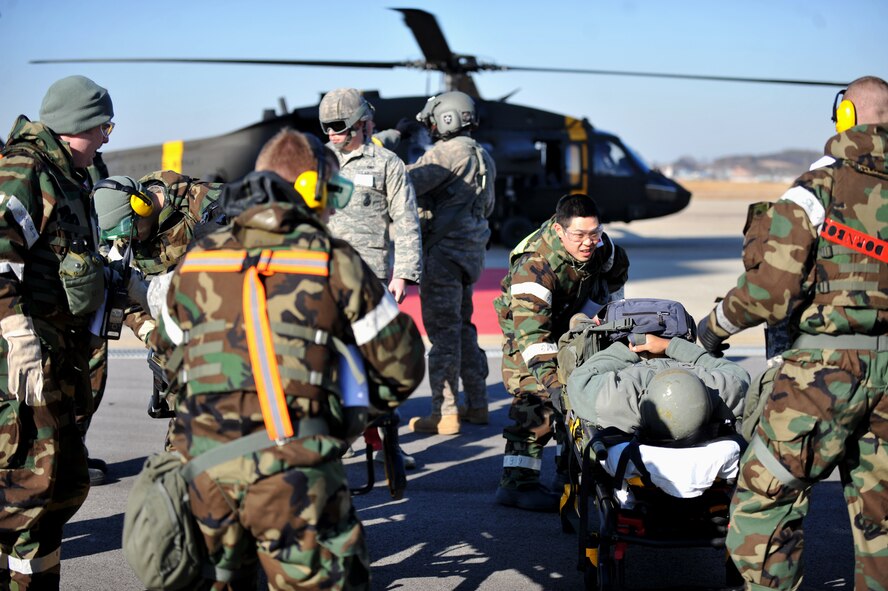 Personnel from the 51st Medical Group transport a simulated casualty from a medical evacuation helicopter toward the group’s triage center during Operational Readiness Exercise Beverly Midnight 14-01 at Osan Air Base, Republic of Korea, Jan. 13, 2014. The scenario exercised the Airmen’s capability to receive casualties from other bases on the Korean peninsula – in this case the patient was simulated as incoming from U.S. Army Garrison Humphries, ROK. (U.S. Air Force photo/Senior Airman Siuta B. Ika)