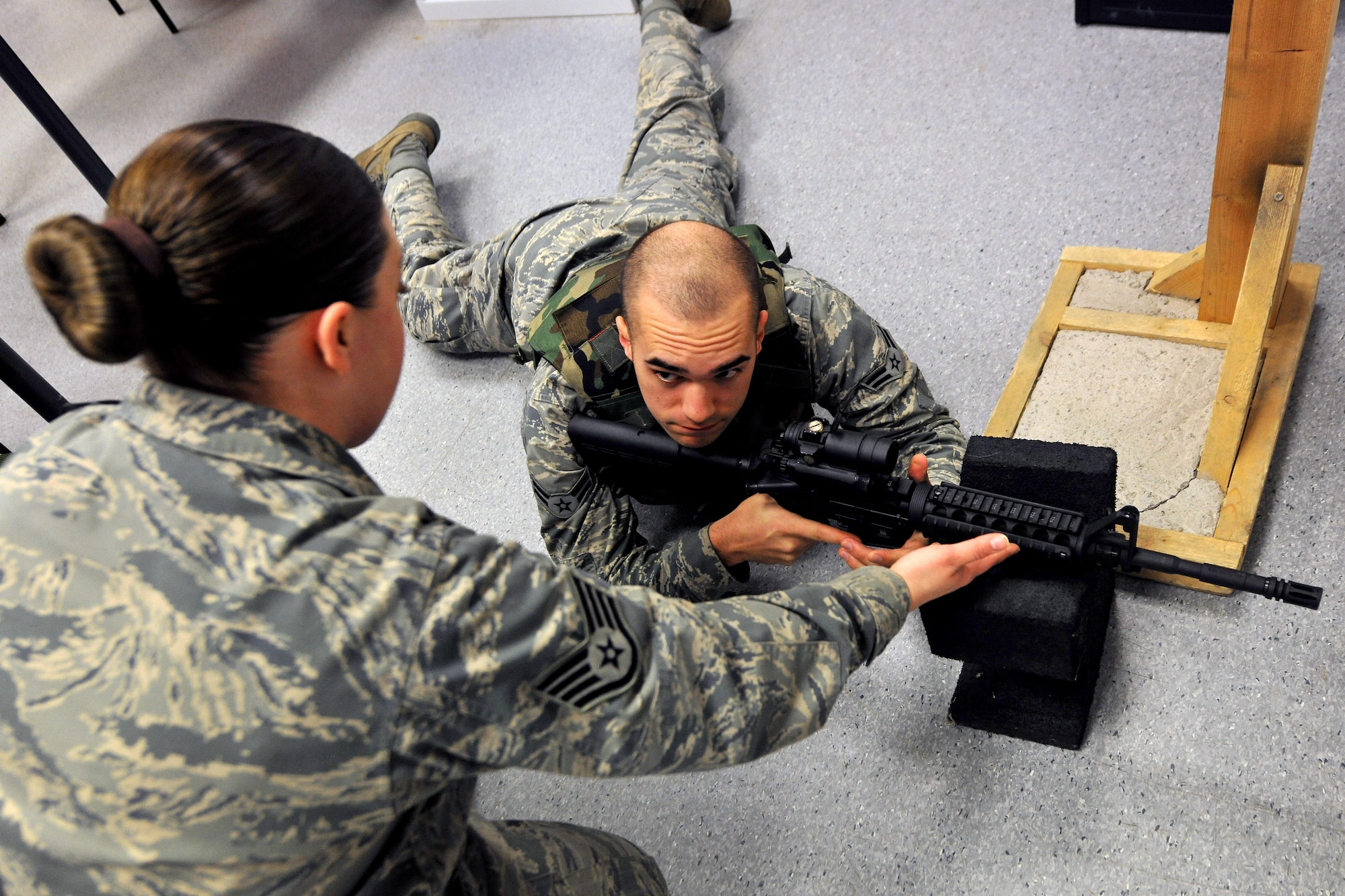 Staff Sgt. Kellie Sawn, U.S. Air Forces Europe 569th Combat Arms Training and Maintenance instructor, teaches the proper prone position to Airman 1st Class Thomas Smith, 86th Airlift Wing Public Affairs broadcaster, during Phase Five weapon training at the firing range, Dec. 18, 2013, Kapaun Station, Germany. The 569th CATM has 15 assigned instructors and are responsible for qualifying the entire Kaiserslautern Military Community area and eight geographical separated units.  (U.S. Air Force photo/Senior Airman Chris Willis)