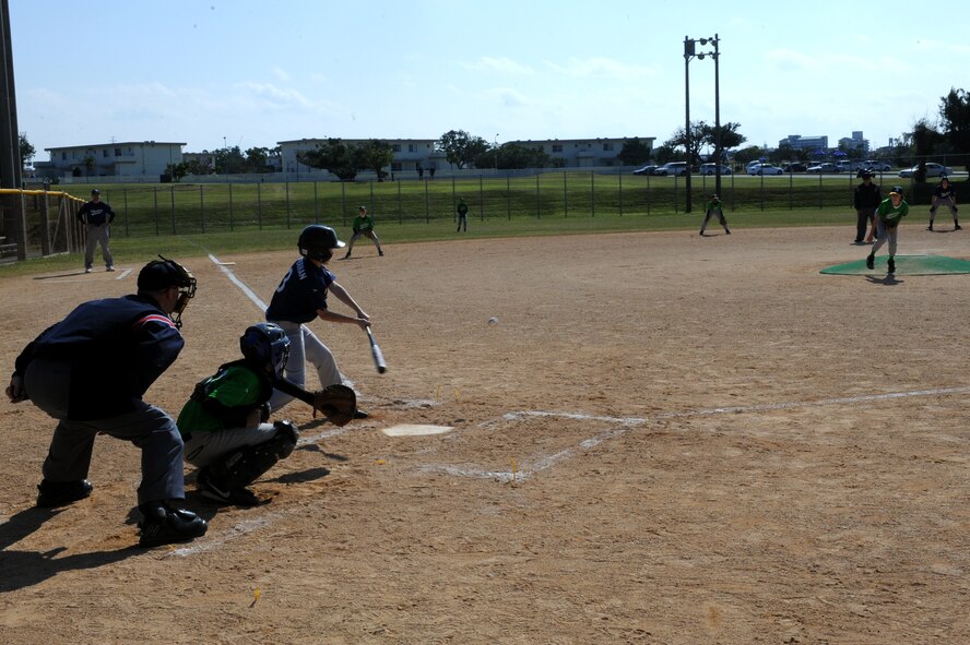A batter from the youth baseball team Yankees hits a ball thrown by a pitcher from team Athletics on opening day of Kadena Air Base’s 2014 youth baseball and softball season on Kadena Air Base, Japan, Jan. 11, 2014. The season’s opening ceremony saw more than 30 youth baseball and softball teams gather to compete. (U.S. Air Force photo by Airman 1st Class Zade C. Vadnais)