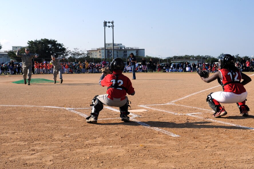 Brig. Gen. James B. Hecker, 18th Wing commander, and Col. Kathleen Weatherspoon, 18th Force Support Squadron commander, throw out the first pitch of the 2014 season for youth baseball and softball respectively on Kadena Air Base, Japan, Jan. 11, 2014. The opening ceremony marked the first time in five years that Kadena has sponsored a youth baseball and softball season. (U.S. Air Force photo by Airman 1st Class Zade C. Vadnais)