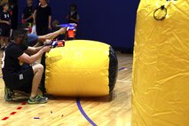 Two Marines from Fleet Antiterrorism Security Team, Central Command hide behind an inflatable obstacle during a Morale, Welfare and Recreation event at Naval Support Activity Bahrain Nov. 21, 2013. Marines from FASTCENT and Command Element, Marine Forces Central Command (Forward) battled against Department of Defense employees’ children for the event where they had to make it across the gym, grab the flag, and return it to their “base,” before the other team.