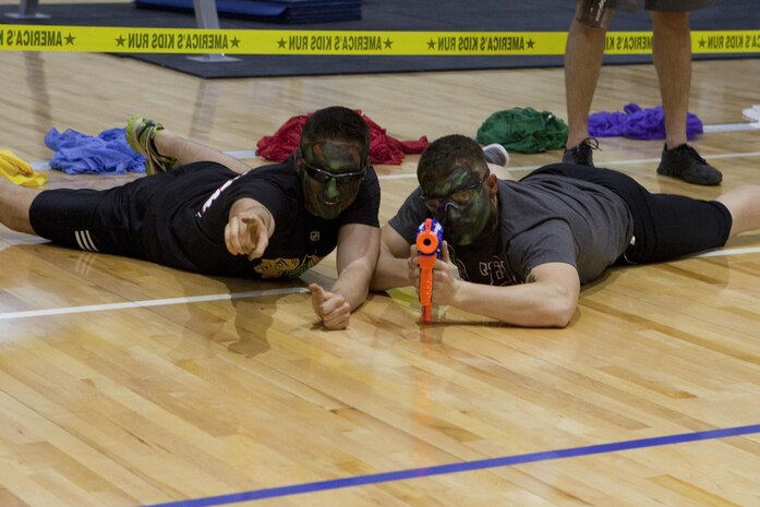 Two Marines from Fleet Antiterrorism Security Team, Central Command prepare to shoot the “enemy” during a Morale, Welfare and Recreation event at Naval Support Activity Bahrain Nov. 21, 2013. Marines from FASTCENT and Command Element, Marine Forces Central Command (Forward) battled against Department of Defense employees’ children for the event where they had to make it across the gym, grab the flag, and return it to their “base,” before the other team.