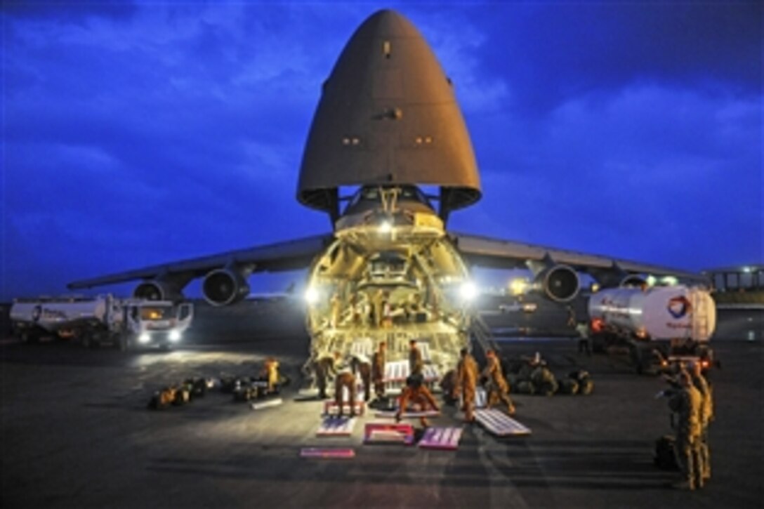 U.S. Navy sailors assemble a modular ramp before offloading a pair of 34-foot patrol boats from an Air Force C-5 Galaxy aircraft at Camp Lemonnier, Djibouti, Jan. 12, 2014. The sailors are assigned to Coastal Riverine Squadron 1.
