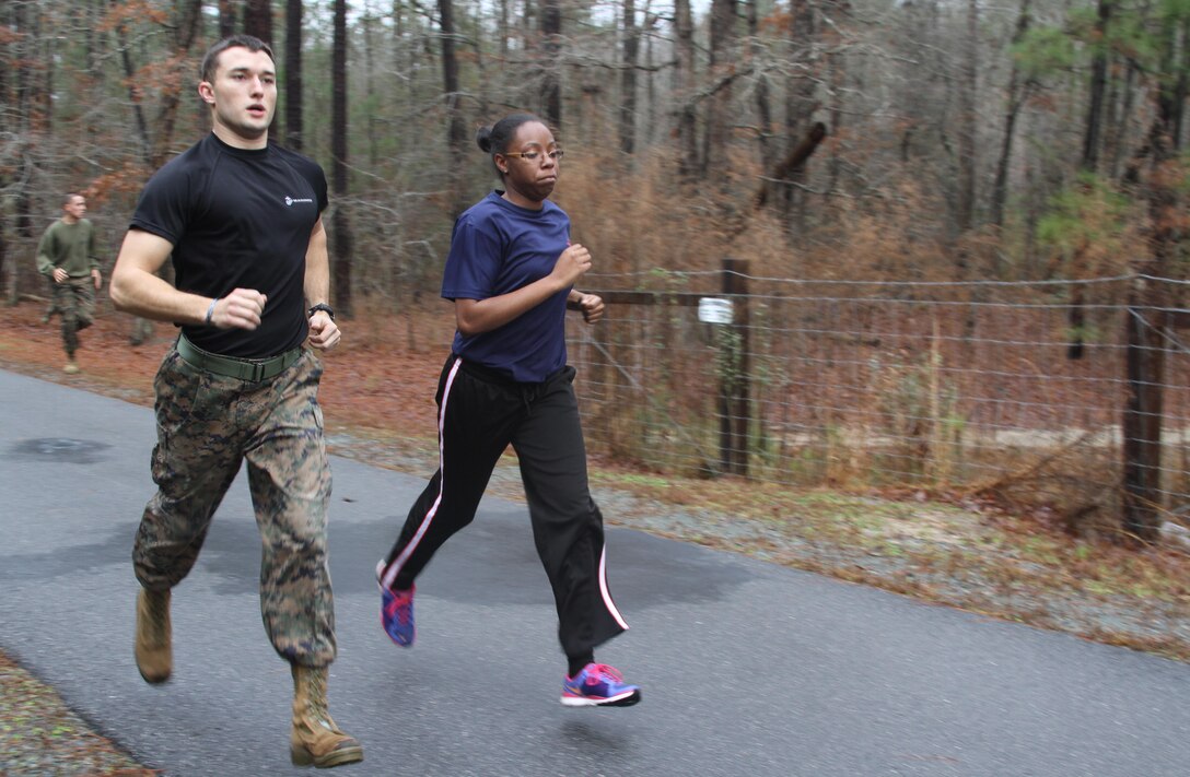 U.S. Marine Corps Sgt. David A. Miller, a recruiter with Marine Corps Recruiting Station Raleigh and Greensboro, N.C., native, motivates a female poolee during the one and a half mile run portion of the initial strength test during the all-female pool function at the Smithfield Aquatic Center in Smithfield, N.C., Jan. 11, 2014. Female poolees from across North Carolina came together to run an initial strength test, consisting of flexed-arm hang, crunches, a one and a half mile run and to learn what boot camp is all about from female drill instructors from Marine Corps Recruit Depot Parris Island, S.C. (U.S. Marine Corps photo by Sgt. Dwight A. Henderson/Released) 