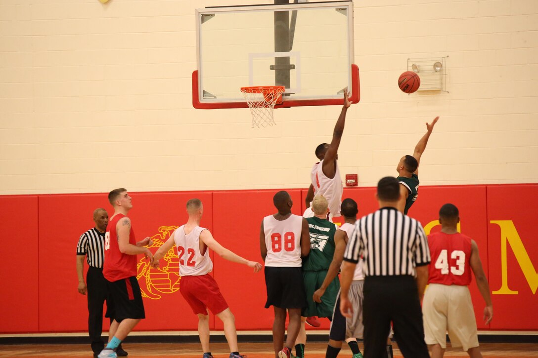 A player from Marine Helicopter Squadron One and a player from The Marine Monitors Section Promotion Branch soar above their teamates in an attempt to get the rebound from a missed shot Monday Jan. 13, 2014, at the Barber Physical Activity Center on Marine Corps Base Quantico. The teams played against eachother in the first game of the 2014 season. 