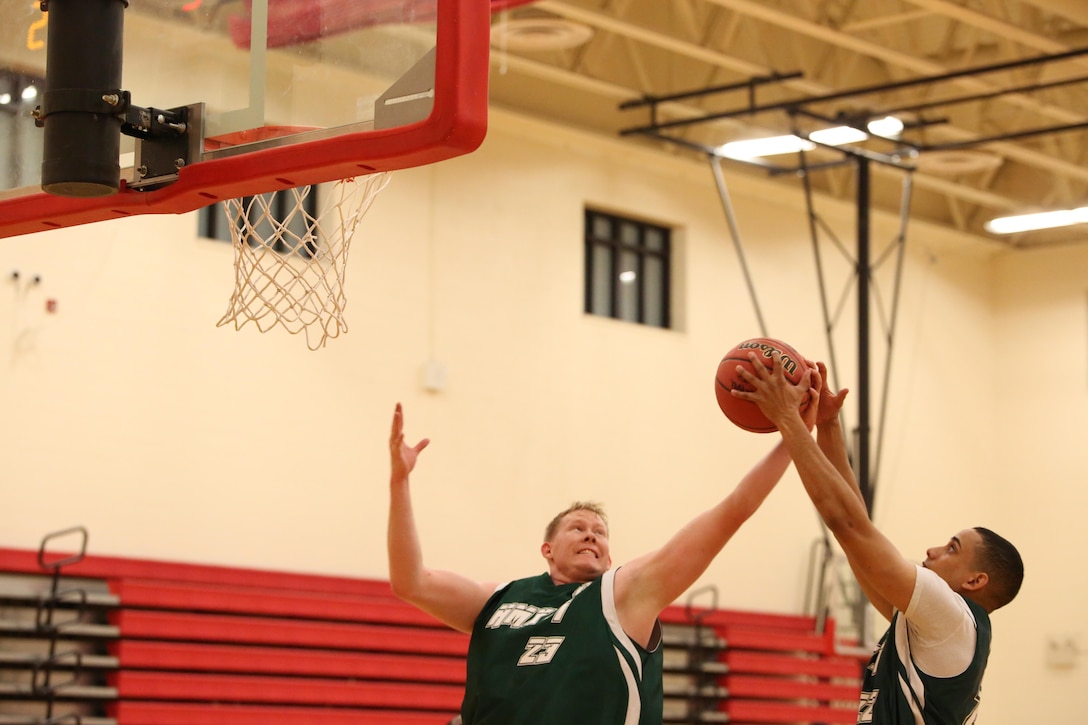 Two players from Marine Helicopter Squadron One's intramural basketball team go for a rebound Monday Jan. 13, 2014, at Barber Physical Activity Center on Marine Corps Base Quantico. HMX-1 went on to lose the game which was the first game of the season.  