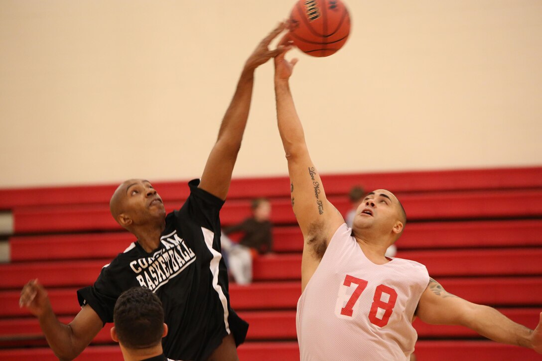 Larry Parker of Combat Camera and Brandon Tutt of the Marine Corps Intelligence Activity basketball teams leap for the tip off on Monday Jan. 13, 2014, at Barber Physical Activity Center on Marine Corps Base Quantico. This was the first game of the year for both teams.  
