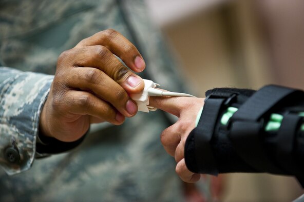 Senior Airman JaMichael Smith checks the temperature of Senior Airman Phou Johnson during an occupational health exam Jan. 10, 2014, at Nellis Air Force Base, Nev. The 99th AMDS is responsible for maintaining and treating all pilots, aircrew and flightline workers in support of flying operations. Smith is a 99th Aerospace Medicine Squadron aerospace technician and Johnson is a 757th Aircraft Maintenance Squadron avionics technician. (U.S. Air Force photo/Senior Airman Brett Clashman)