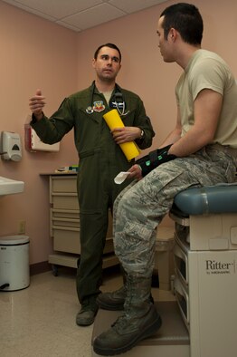 Capt. (Dr.) Thomas Shute explains multiple causes for hearing problems to Senior Airman Phou Johnson during a follow-up occupational health exam Jan. 10, 2014, at Nellis Air Force Base, Nev. Hearing problems commonly occur from the improper use of cotton swabs in the ear. Shute is a 42nd Attack Squadron flight surgeon and Phou is a 757th Aircraft Maintenance Squadron avionics technician. (U.S. Air Force photo/Airman 1st Class Timothy Young)