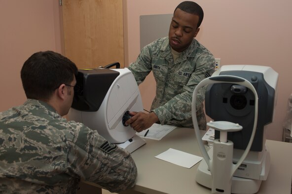 Senior Airman JaMicheal Smith conducts an eye exam on a patient Jan. 10, 2014, at Nellis Air Force Base, Nev. Regular eye exams are conducted to ensure work related sight problems can be quickly found and treated. Smith is a 99th Aerospace Medicine Squadron aerospace technician. (U.S. Air Force photo/Airman 1st Class Timothy Young)