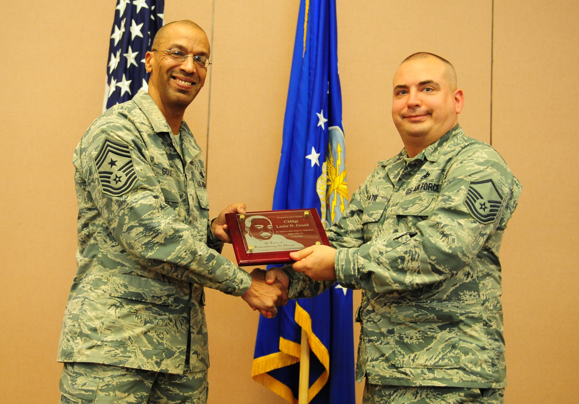 Chief Master Sgt. Leslie Gould (left), 9th Reconnaissance Wing command chief, receives a plaque for serving as the guest speaker of the annual Dr. Martin Luther King, Jr. Day luncheon from Master Sgt. Marc Pato, 9th Maintenance Operations Squadron maintenance management analysis superintendent, on Jan. 15, 2014, at Beale Air Force Base, Calif. Gould recited many of the words used by King during his “I Have a Dream” speech of 1963. (U.S. Air Force photo by Airman 1st Class Bobby Cummings/released)