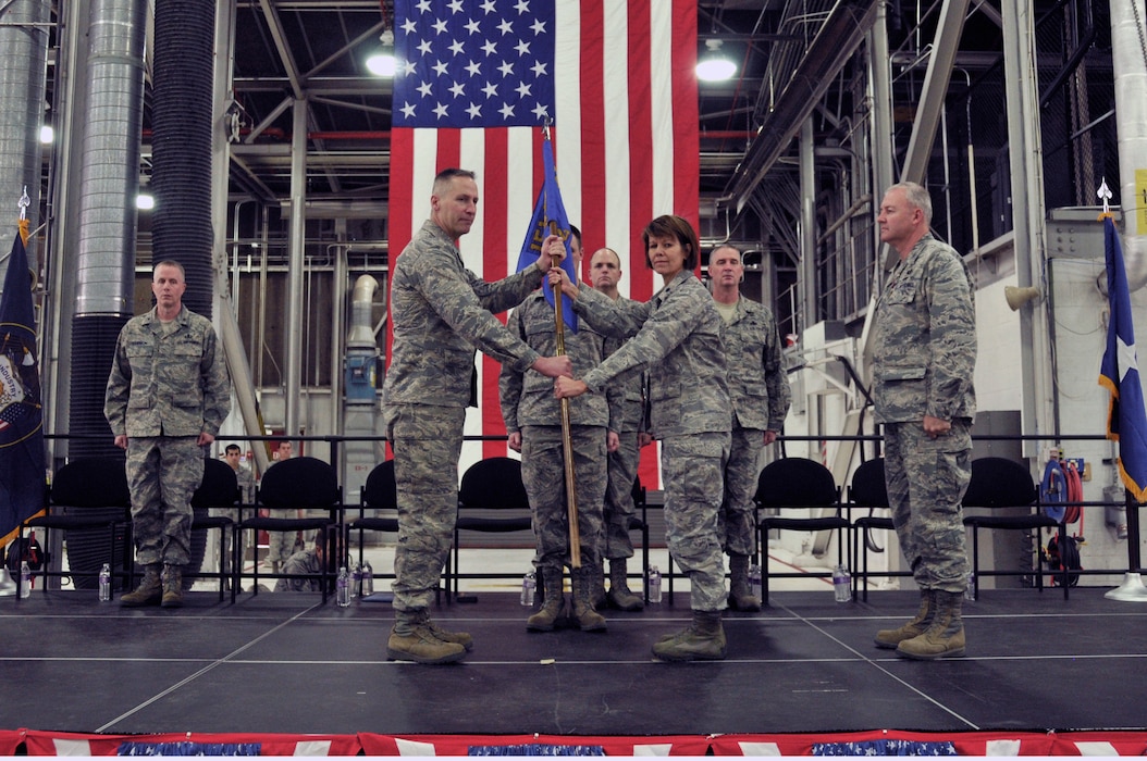 Col. Darwin L. Craig presents Lt. Col. Susan L. Melton with the unit flag during the 151st Maintenance Group Change of Command.  Col. David P. Osborne relinquished command to Lt. Col. Melton at the January 11, 2014 ceremony held at the Utah Air National Guard Base. (Utah National Guard Photo by SSgt Annie Edwards/released)