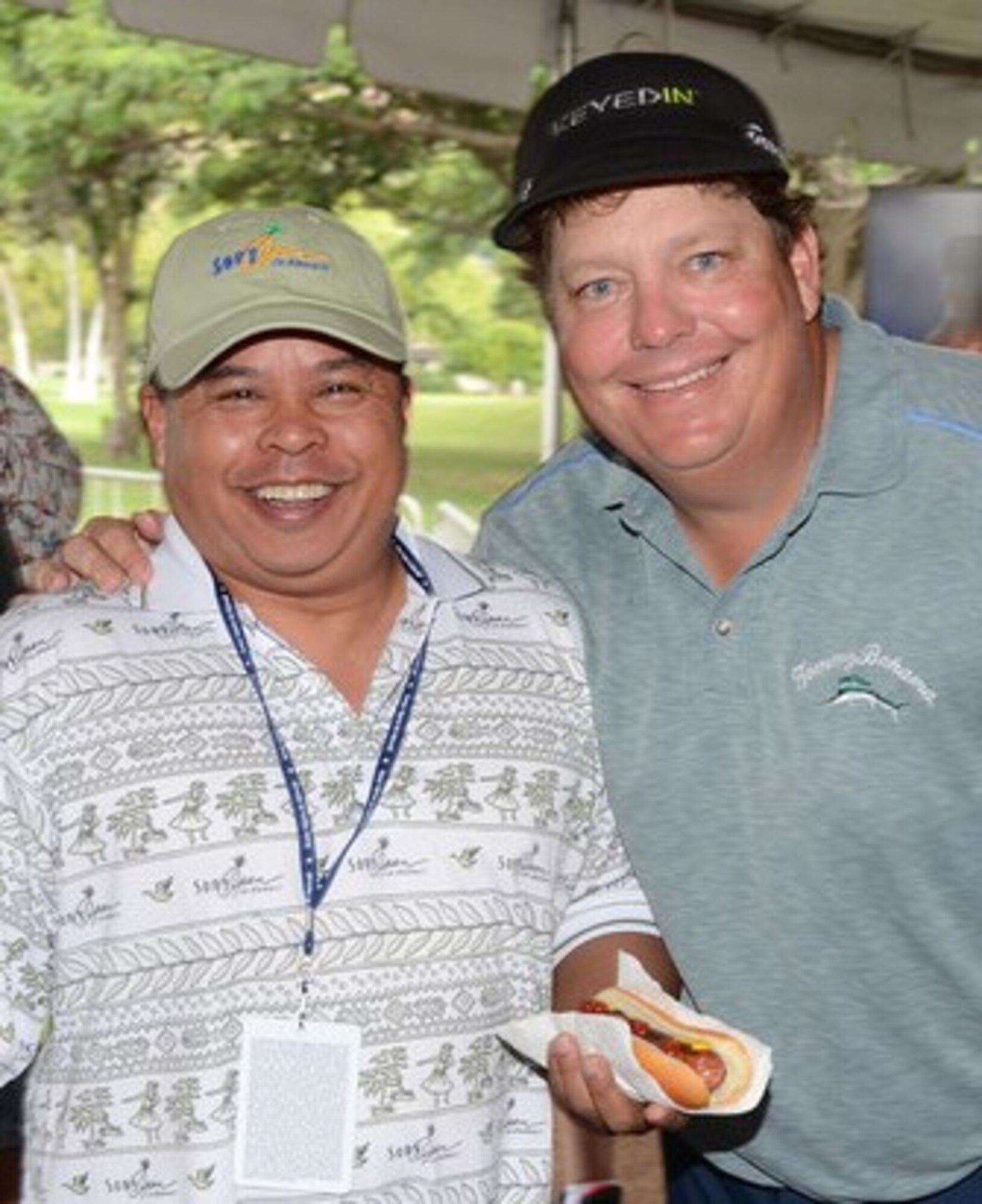 Tech. Sgt. Ed Dumlao, a water fuels systems maintenance journeyman with the 624th Civil Engineering Squadron, poses for a photo with pro golfer Tim Herron in the military appreciation tent on the 18th fairway at the Sony Open, Waialae Country Club, Honolulu, Hawaii, Jan. 12, 2014. Herron, a golfer from Minnesota, who according to Wikipedia played in 494 PGA Tour events through 2013, stopped by the tent after his round to thank service members and their families. (Courtesy photo by Tobias Manuputy/Released)