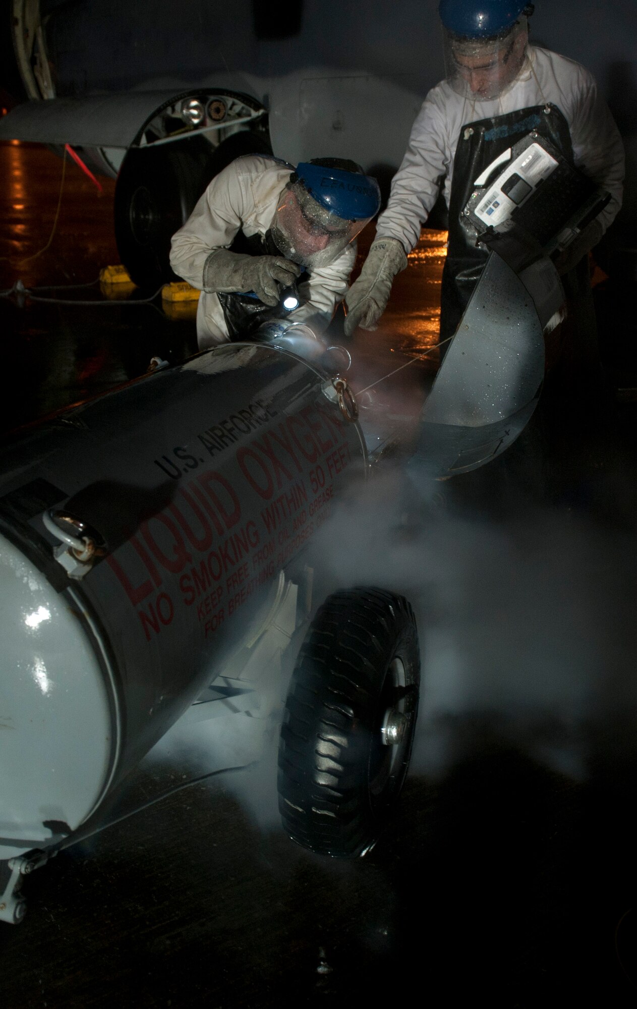 Airman 1st Class Mark Sherwood, left, and Staff Sgt. Luke Brackin, 1st Special Operations Aircraft Maintenance Squadron crew chiefs, read a technical order while starting up a liquid oxygen cart on the flightline at Hurlburt Field, Fla., Jan. 13, 2014. Technical orders are step-by-step instruction manuals maintainers use to fix equipment. (U.S. Air Force photo/Senior Airman Krystal M. Garrett) 