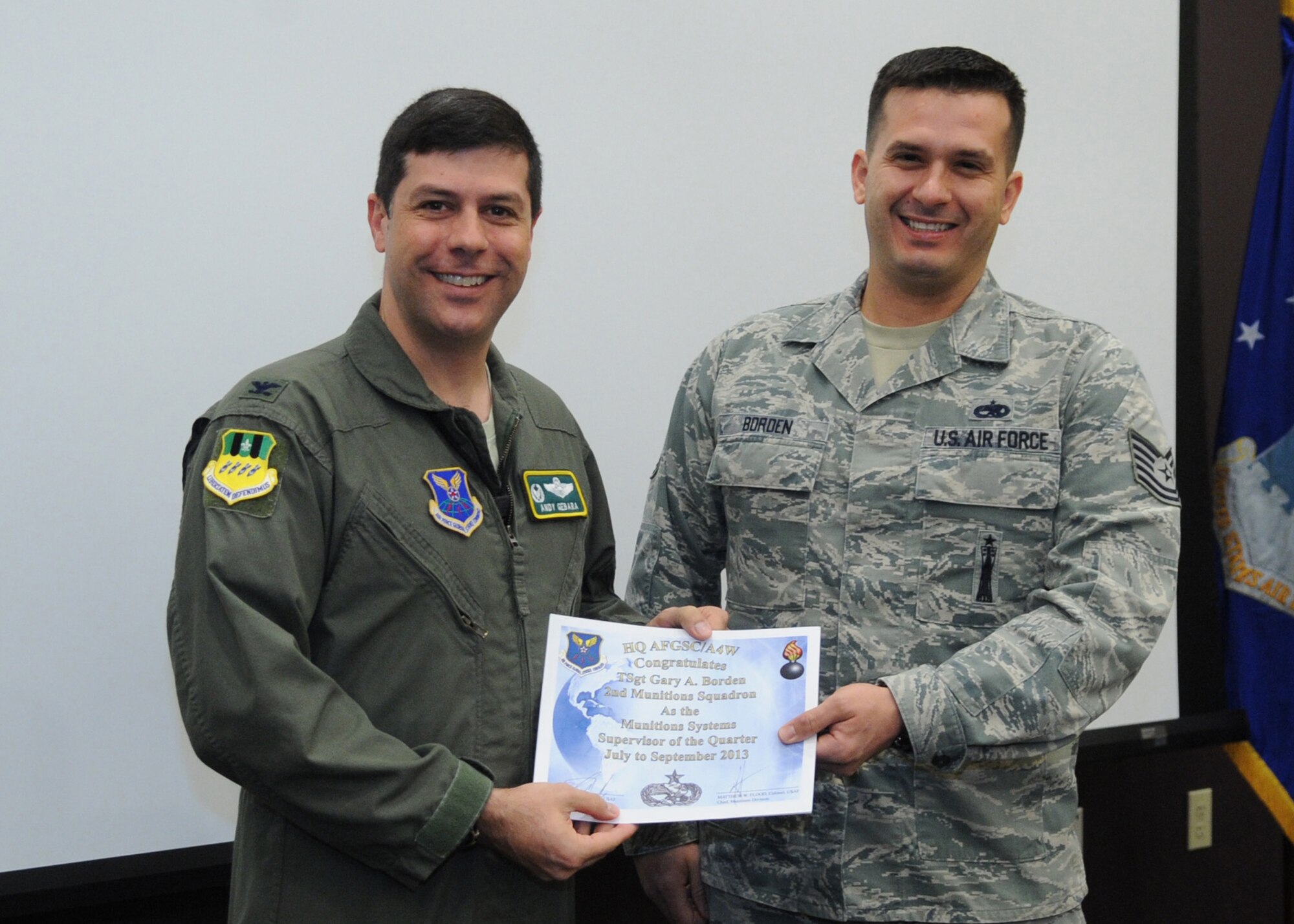 Col. Andrew Gebara, 2nd Bomb Wing commander, poses with Tech. Sgt. Gary Borden, 2nd Munitions Squadron munitions inspector, during Wing Stand Up on Barksdale Air Force Base, La., Jan. 8, 2014. Borden received the Distinguished Graduate Award during NCO Academy as well as Munitions Systems Supervisor of the Quarter. (U.S. Air Force photo/Senior Airman Kristin High)