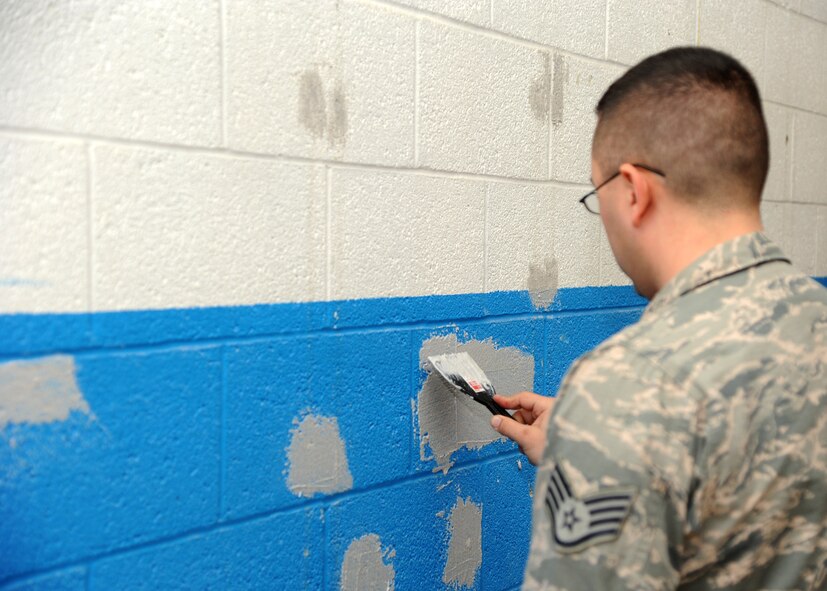 Staff Sgt. Daniel Bell, 307th RED HORSE Civil Engineer Squadron structural engineer, patches the wall at the Airman Leadership School gym on Barksdale Air Force Base, La., Jan. 12, 2014. Bell used Ready-Mixed Concrete to fill holes in the cinderblock. The wall will be painted after the remaining holes are filled with concrete. (U.S. Air Force photo/Senior Airman Joseph A. Pagán Jr.)