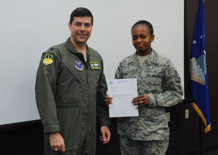 Col. Andrew Gebara, 2nd Bomb Wing commander, poses with Tech. Sgt. Shanaysha Evans, 2nd Medical Operations Squadron women?s health NCO in-charge, during Wing Stand Up on Barksdale Air Force Base, La., Jan. 8, 2014. Evans received the Distinguished Graduate Award while attending NCO Academy. (U.S. Air Force photo/Senior Airman Kristin High)
