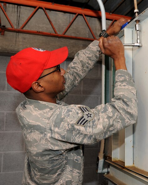 Senior Airman Jamorri Ware, 307th RED HORSE Civil Engineer Squadron heating, ventilation, air conditioning, and refrigeration, loosens a bolt at the Airman Leadership School gym on Barksdale Air Force Base, La., Jan. 11, 2014. Ware is removing an old HVAC unit from the gym to make room for a new one. (U.S. Air Force photo/Senior Airman Joseph A. Pagán Jr.)