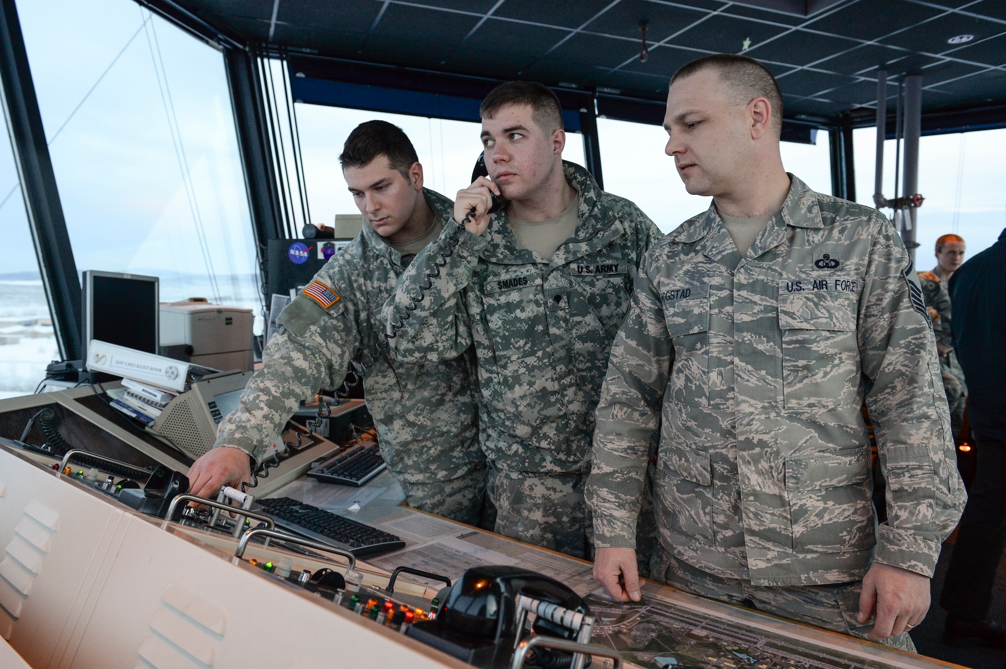 U.S. Army Spcs. Paul Murray and Christopher Smades, Fox Company 1-51, Aviation Battalion air traffic control specialists, practice standard control tower measures with Master Sgt. Dustin Rogstad, 354th Operations Support Squadron tower control chief, Jan. 14, 2014, Eielson Air Force Base, Alaska. Murray and Smades have been training since August with Air Force controllers on fixed-wing air traffic control procedures. (U.S. Air Force photo by Airman 1st Class Peter Reft/Released)