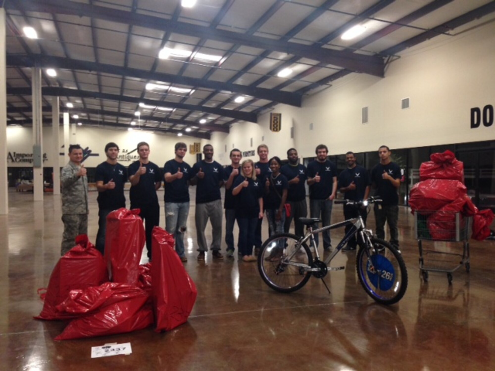 Staff Sgt. Charles Hefner, left, and members of his Delayed Entry Program, give the thumbs up after wrapping presents for the Angel Tree program in Tupelo, Miss. (U.S. Air Force photo)