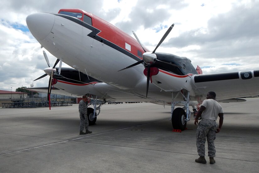Members of Joint Task Force-Bravo's 612th Air Base Squadron receive a DC-3 aircraft on the flightline at Soto Cano Air Base, Honduras, Dec. 13, 2014.  The DC-3 is from the Naval Oceanographic office and will be used to conduct laser mapping operations off the coast of Honduras.  (U.S. Air Force photo by Tech. Sgt. Stacy Rogers)