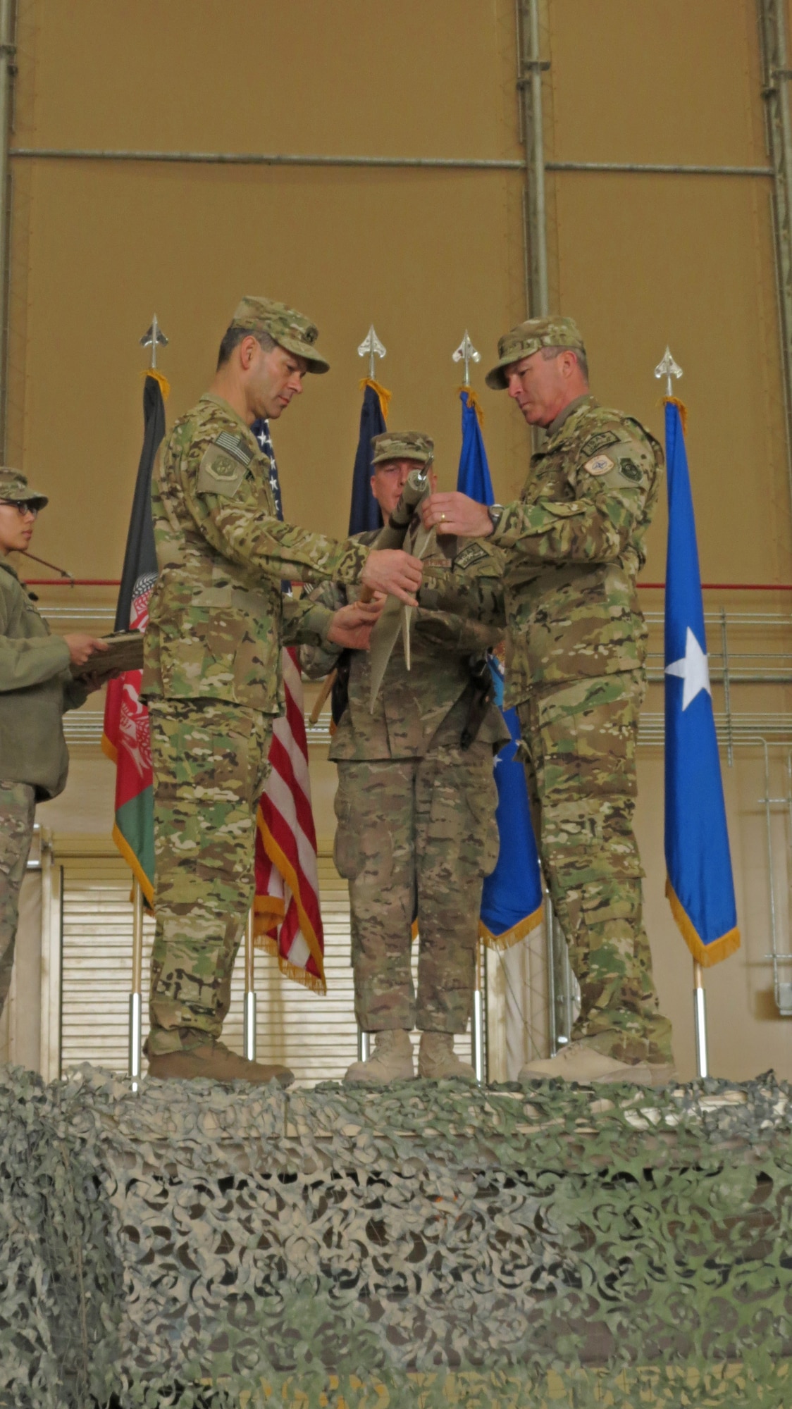 U.S. Air Force Maj. Gen. Kenneth Wilsbach, Commander, 9th Air and Space Expeditionary Task Force-Afghanistan; Deputy Commander-Air, U.S. Force-Afghanistan; and Deputy Chief of Staff-Air, International Security Assistance Force Joint Command, furls the 451st Air Expeditionary Wing guidon with Brig. Gen. Michael Frantini, 451st AEW commander and Commander, Kandahar Airfield, in a transition ceremony at Kandahar Airfield, Afghanistan, Jan. 13, 2014. The 451st Air Expeditionary Wing was transitioned to an Air Expeditionary Group due to a change in mission.(U.S. Air Force photo by Senior Airman Alexandria Bandin/Released)