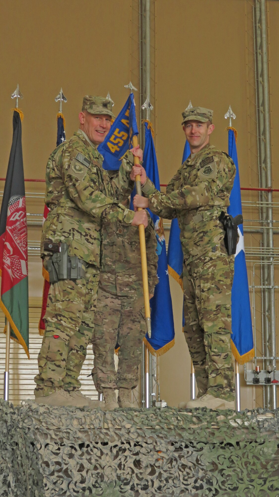 U.S. Air Force Col. Scott Campbell, 451st Air Expeditionary Group commander, receives the new 451st AEG guidon from Brig. Gen. Patrick Malackowski, 455th Air Expeditionary Wing commander, in a transition ceremony at Kandahar Airfield, Afghanistan, Jan. 13, 2014. The 451st Air Expeditionary Wing was transitioned to an AEG due to a change in mission.(U.S. Air Force photo by Senior Airman Alexandria Bandin/Released)      