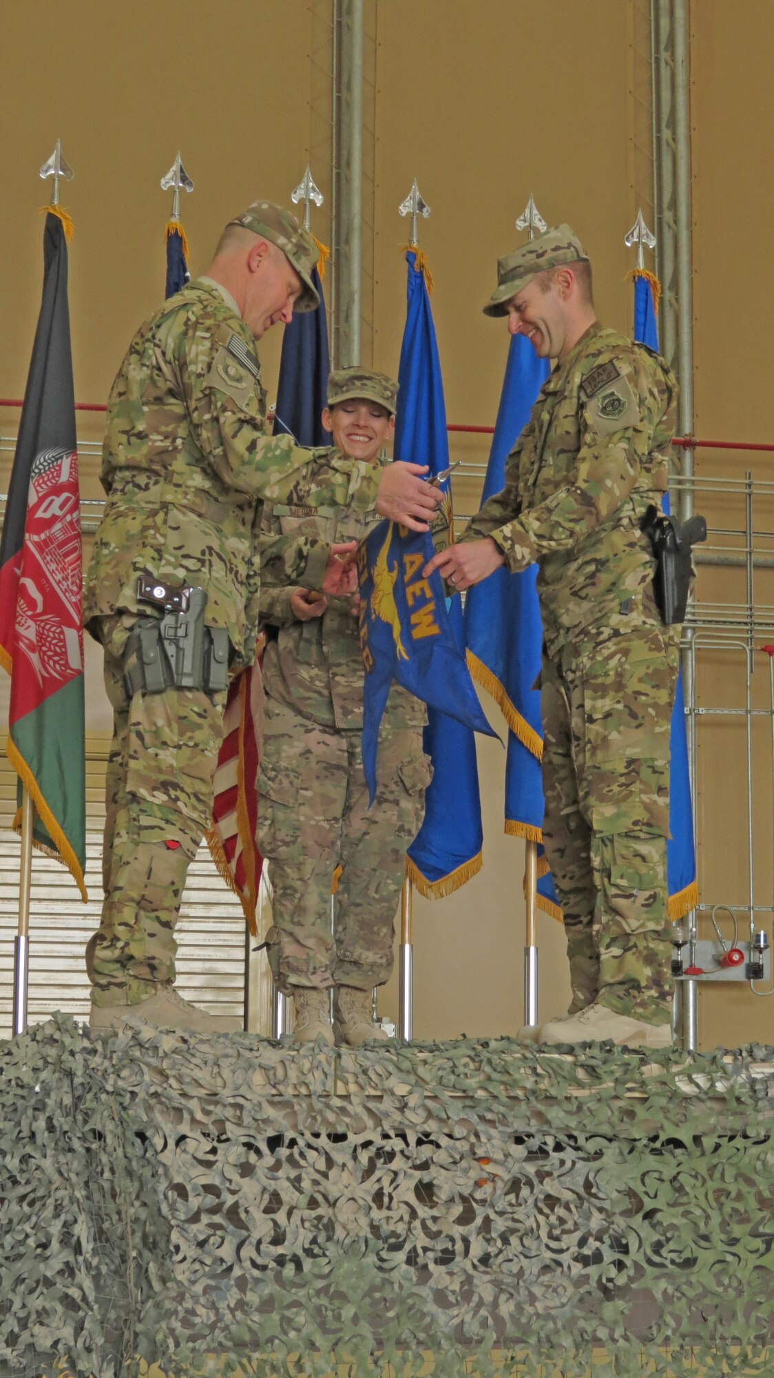 U.S. Air Force Brig. Gen. Patrick Malackowski, 455th Air Expeditionary Wing commander and Col. Scott Campbell, 451st Air Expeditionary Group commander, unfurl the new 451st AEG guidon in a transition ceremony at Kandahar Airfield, Afghanistan, Jan. 13, 2014. The 451st Air Expeditionary Wing was transitioned to an AEG due to a change in mission.(U.S. Air Force photo by Senior Airman Alexandria Bandin/Released)                              
