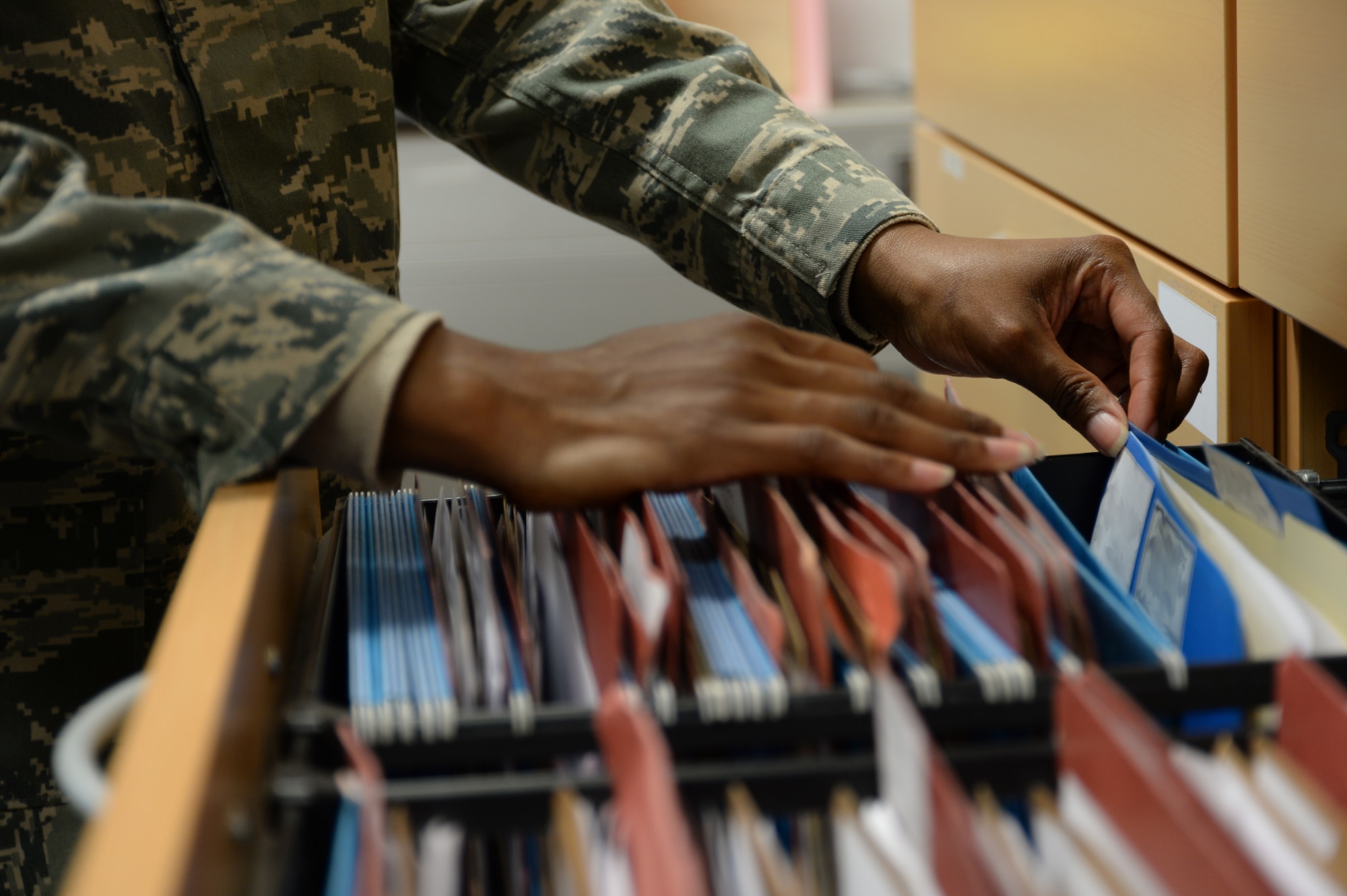 SPANGDAHLEM AIR BASE, Germany -- Tech. Sgt. Tena Briscoe, unit deployment manager of 606th Air Control Squadron of Baltimore, Md., sorts through a file cabinet at her squadron's headquarters Jan. 13, 2014. Briscoe processes files relating to deployments and training for her entire squadron. (U.S. Air Force illustration by Staff Sgt. Joe W. McFadden / Released)