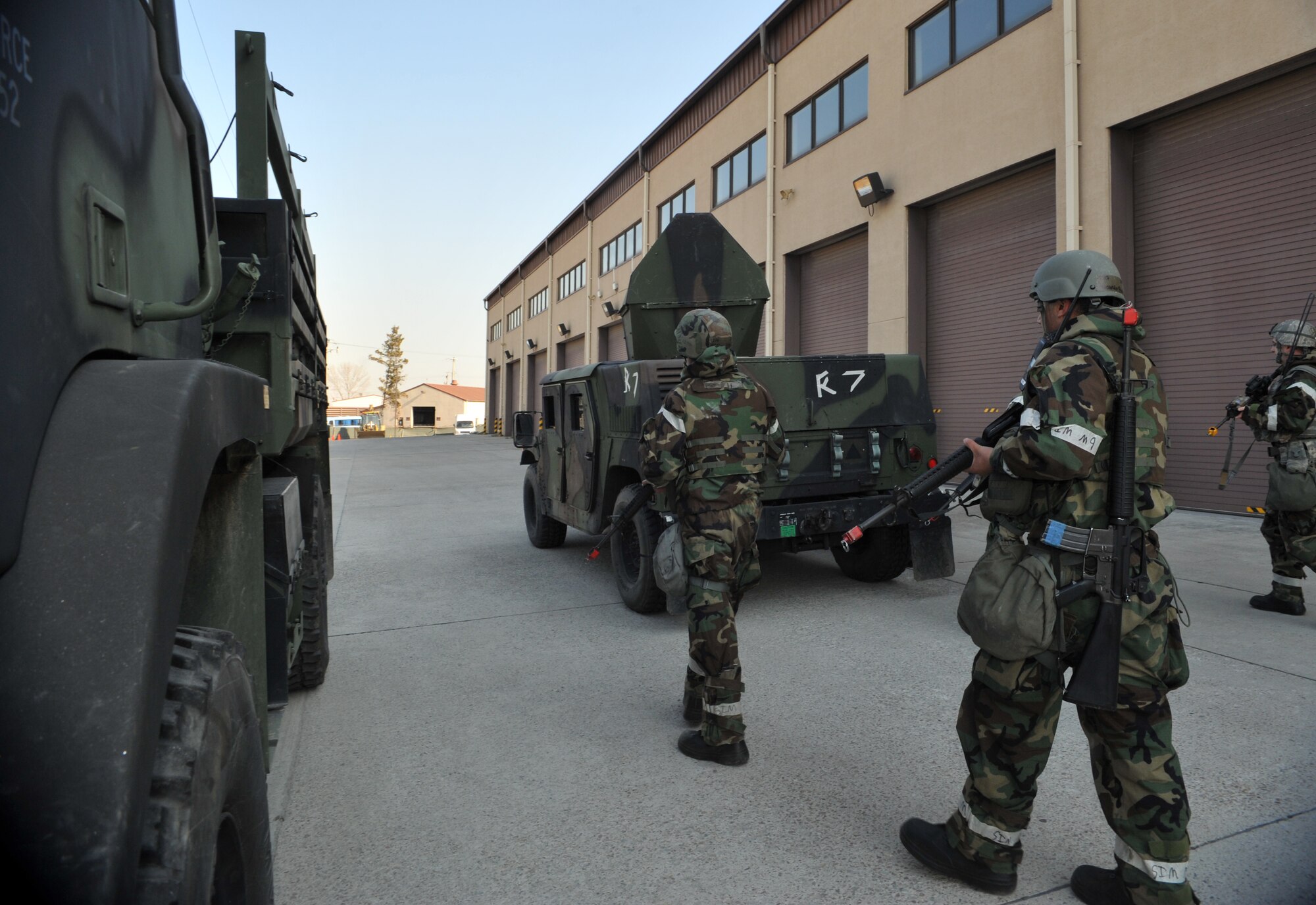 Airmen from the 51st Logistics Readiness Squadron patrol their squadron’s vehicle compound as part of a simulated ground attack scenario during Operational Readiness Exercise Beverly Midnight 14-01 at Osan Air Base, Republic of Korea, Jan. 14, 2014. The Airmen, along with members of the 51st Security Forces Squadron, practiced responding to an attack while wearing Mission Oriented Protective Posture Level 2 gear. (U.S. Air Force photo/Airman 1st Class Ashley J. Thum)