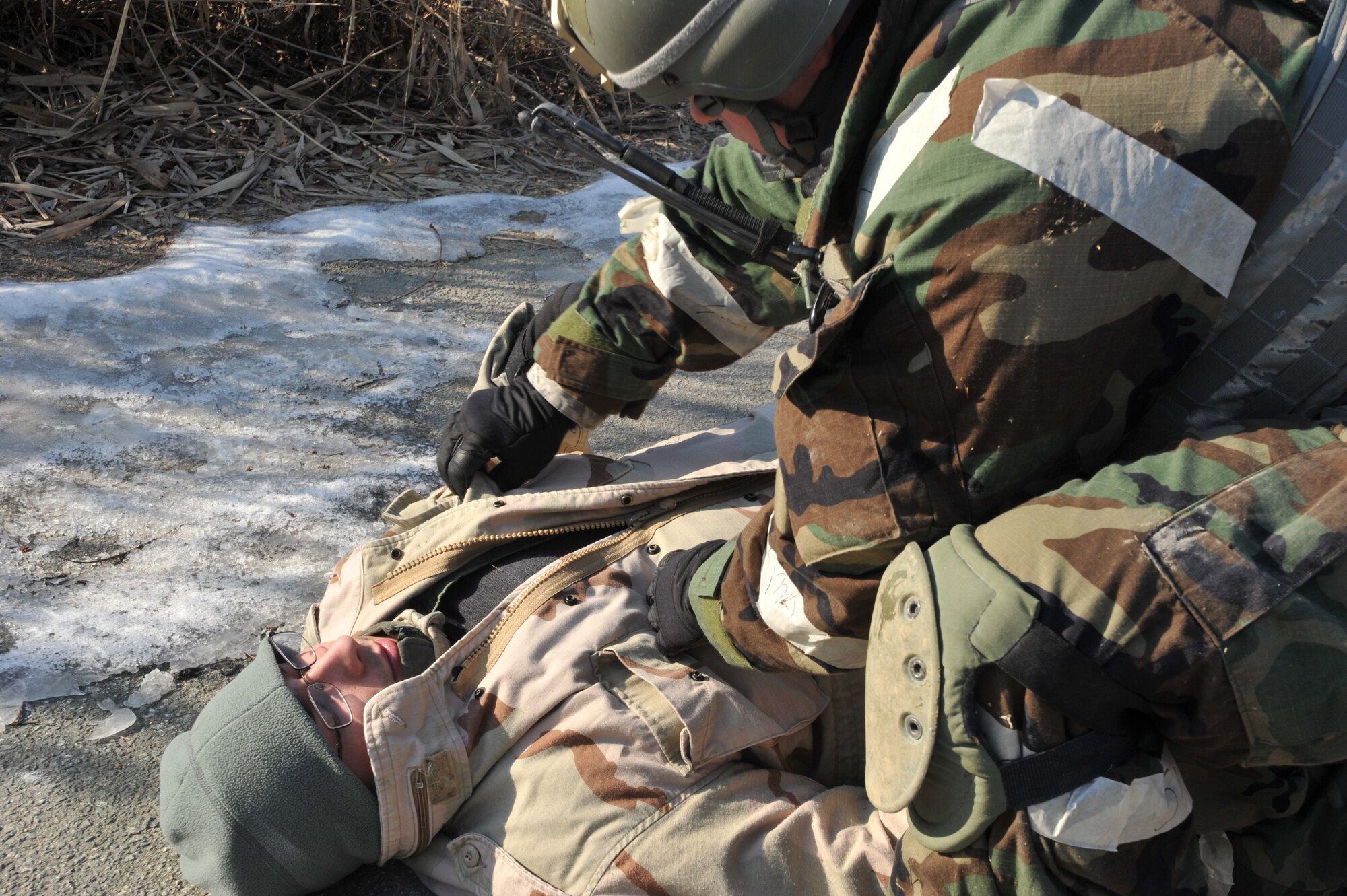 Tech. Sgt. Dwayne Davis, a member of the 51st Security Forces Squadron, initiates a body search on an opposition forces role player acting as a casualty during Operational Readiness Exercise Beverly Midnight 14-01 in a training area outside Osan Air Base, Republic of Korea, Jan. 14, 2014. Defenders are required to examine enemy forces to determine if they are carrying any hidden weapons or other dangerous items. (U.S. Air Force photo/Airman 1st Class Ashley J. Thum)