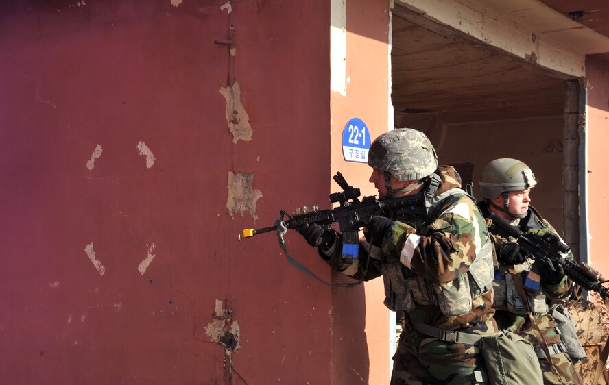A member of the 51st Security Forces Squadron prepares to advance further into his environment while another defender monitors their previously cleared territory during Operational Readiness Exercise Beverly Midnight 14-01 in a training area outside Osan Air Base, Republic of Korea, Jan. 14, 2014. The Airmen were part of a training scenario in which opposition forces role players from several units on base staged a simulated ground attack. (U.S. Air Force photo/Airman 1st Class Ashley J. Thum) 