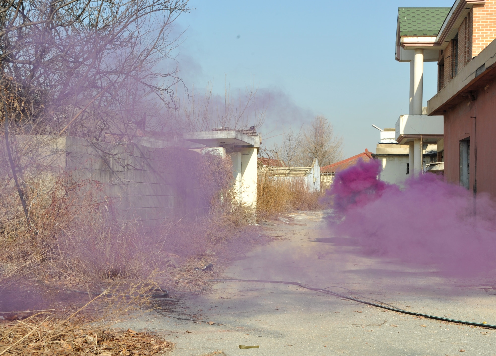 Purple smoke canisters help create a real-world atmosphere as part of an Operational Readiness Exercise Beverly Midnight 14-01 scenario in a training area outside Osan Air Base, Republic of Korea, Jan. 14, 2014. Personnel from the 51st Security Forces Squadron and the ROK air force were tasked with clearing the area of any opposition forces role players to sharpen the defensive techniques they would use during an actual ground attack. (U.S. Air Force photo/Airman 1st Class Ashley J. Thum)