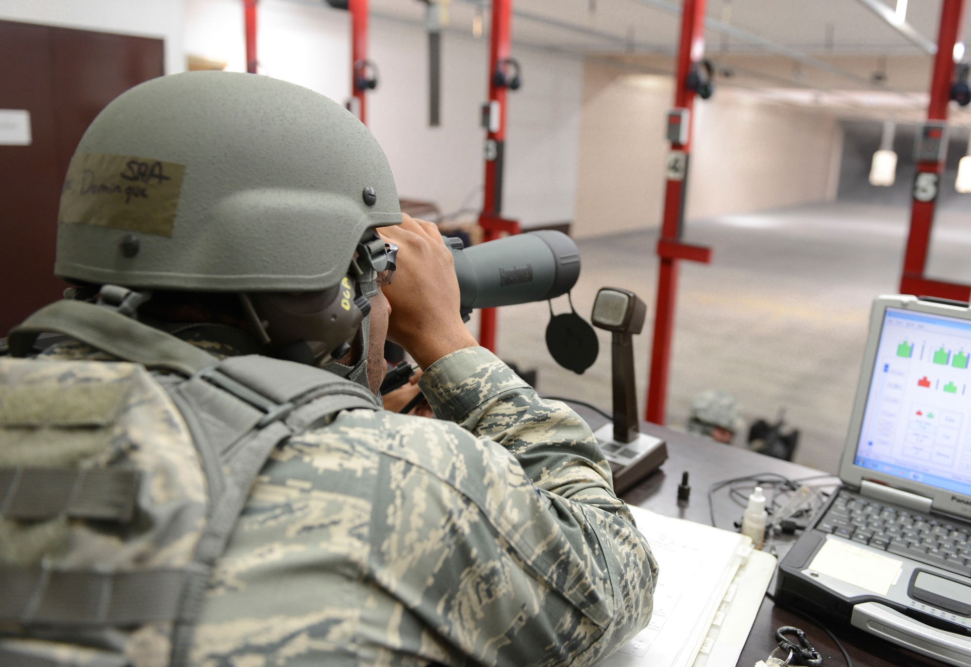 Senior Airman Dominique Cortez Adams, 374th Security Forces Squadron combat arms instructor, watches through the scope for the shots being fired at the targets at Yokota Air Base, Japan, Jan. 15, 2014.  Once everyone is finished firing they are graded on their shooting and make eye sight corrections on their weapon. (U.S. Air Force photo by Airman 1st Class Meagan Schutter/Released)