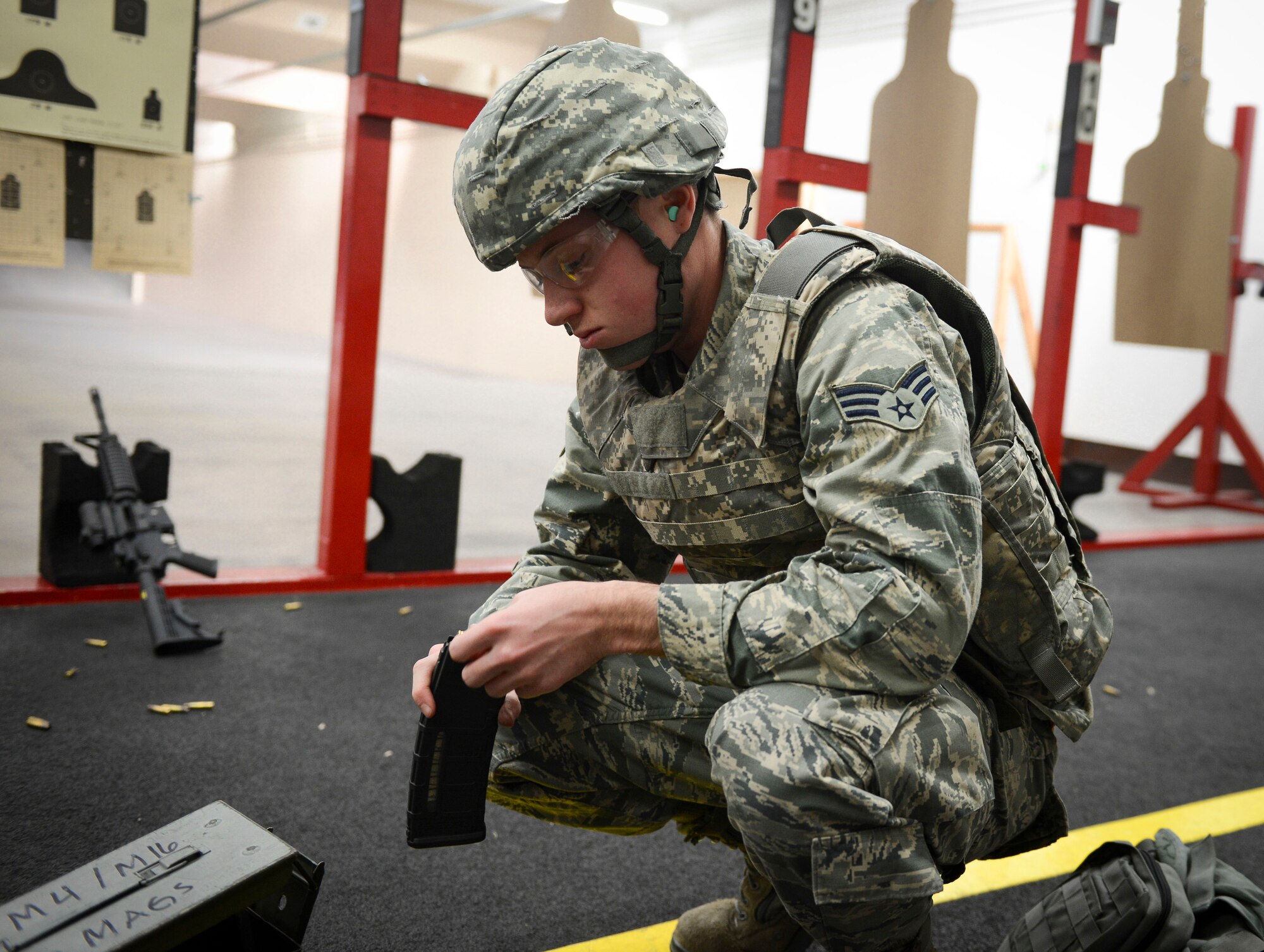 Senior Airman Jacob Haynes, 374th Logistics Readiness Squadron fuels specialist, loads a magazine before the next round starts of shooting at Yokota Air Base, Japan, Jan. 15, 2014.  There are three main positions used for qualifying: prone, kneeling and standing position. (U.S. Air Force photo by Airman 1st Class Meagan Schutter/Released)